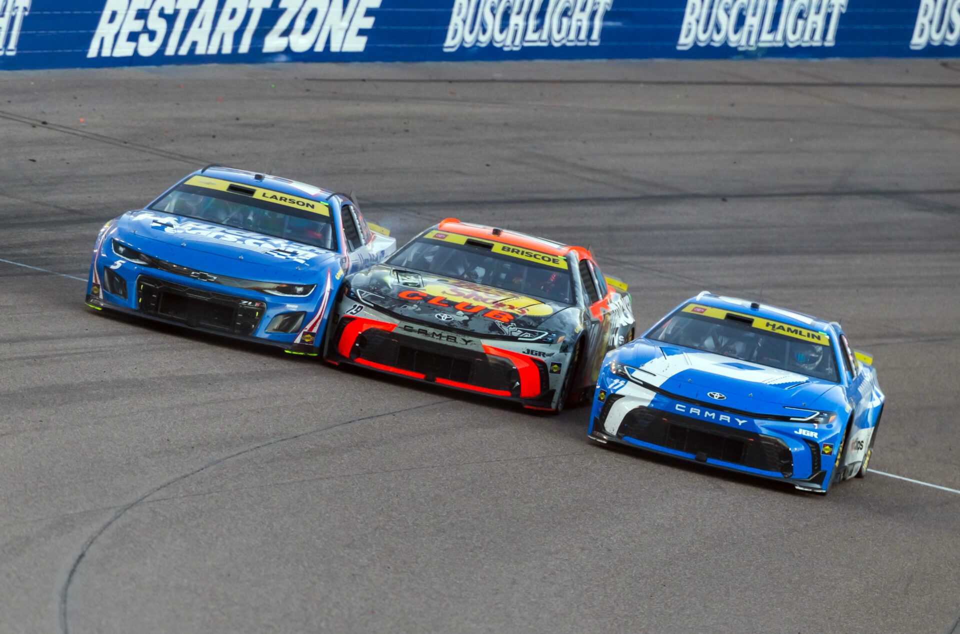 NASCAR Cup Series driver Kyle Larson (5) goes three wide with Chase Briscoe (19) and Denny Hamlin (11) during the NASCAR Championship race at Phoenix Raceway.
