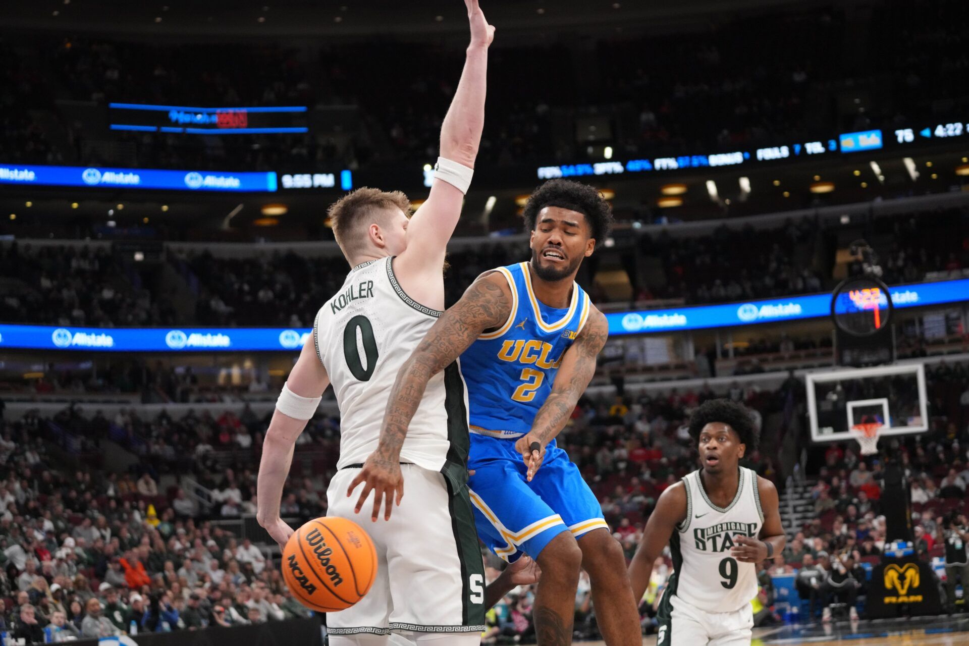 UCLA Bruins guard Donovan Dent (2) passes the ball around Michigan State Spartans forward Jaxon Kohler (0) during the second half at United Center.