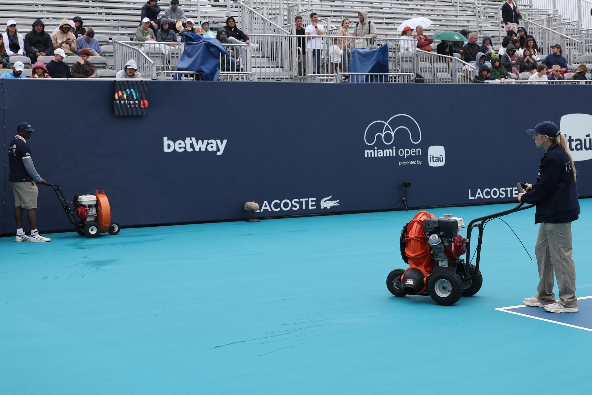 Workers dry Butch Buchholz Court during a rain delay on day 2 of the 2026 Miami Open at Hard Rock Stadium.