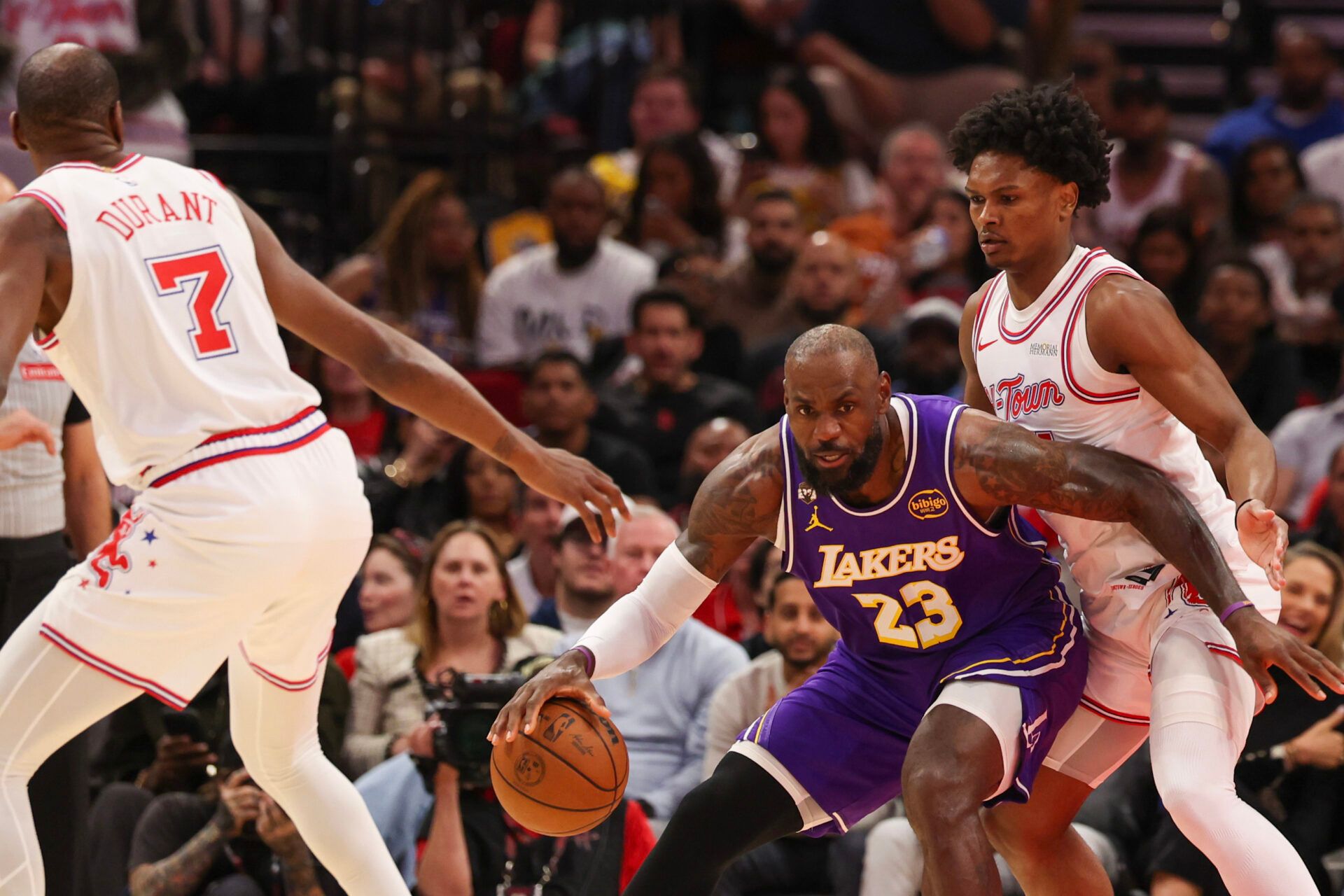 Los Angeles Lakers forward LeBron James (23) dribbles against Houston Rockets guard Amen Thompson (1) and forward Kevin Durant (7) in the first quarter at Toyota Center.