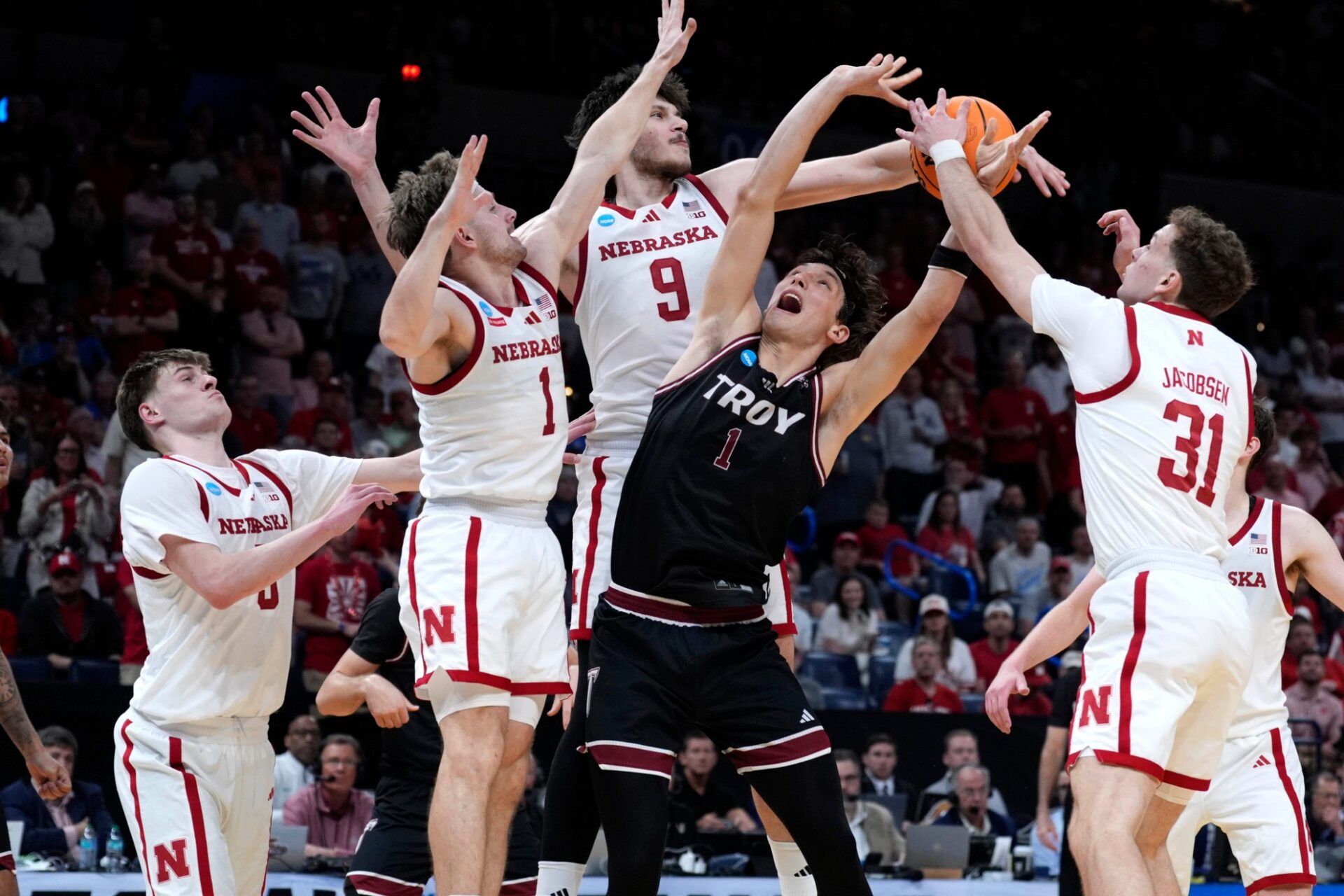 Troy Trojans forward Thomas Dowd (1) has his shot block as Nebraska Cornhuskers forward Braden Frager (5), Sam Hoiberg (1), Berke Buyuktuncel (9) and Cale Jacobsen (31) defend during a first-round game in the NCAA men's basketball tournament between Nebraska and Troy at Paycom Center in Oklahoma City, Thursday, March 19, 2026.