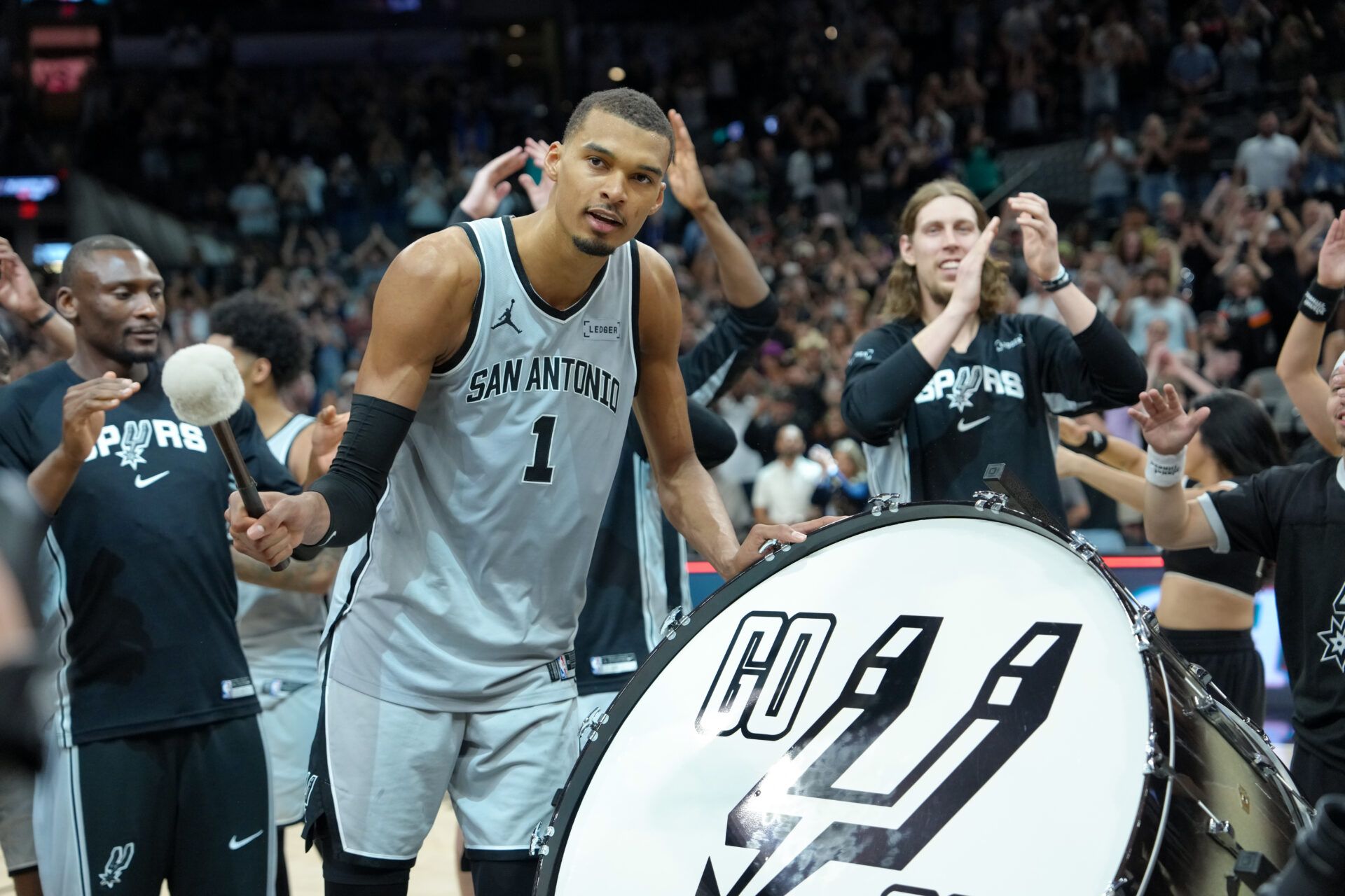 San Antonio Spurs forward Victor Wembanyama (1) beats the drum after the game against the Phoenix Suns at Frost Bank Center.