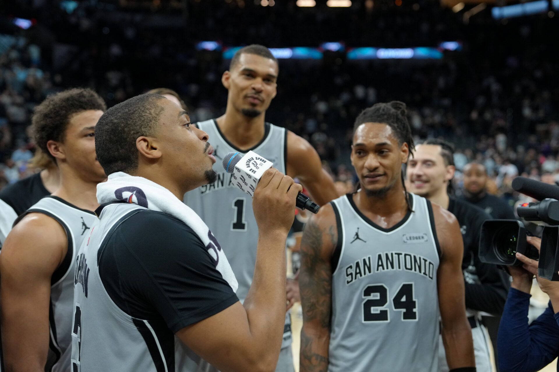 San Antonio Spurs forward Keldon Johnson (3) addresses the crowd in front of forwards Carter Bryant (11), Victor Wembanyama (1), and guard Devin Vassell (24) after the game against the Phoenix Suns at Frost Bank Center.