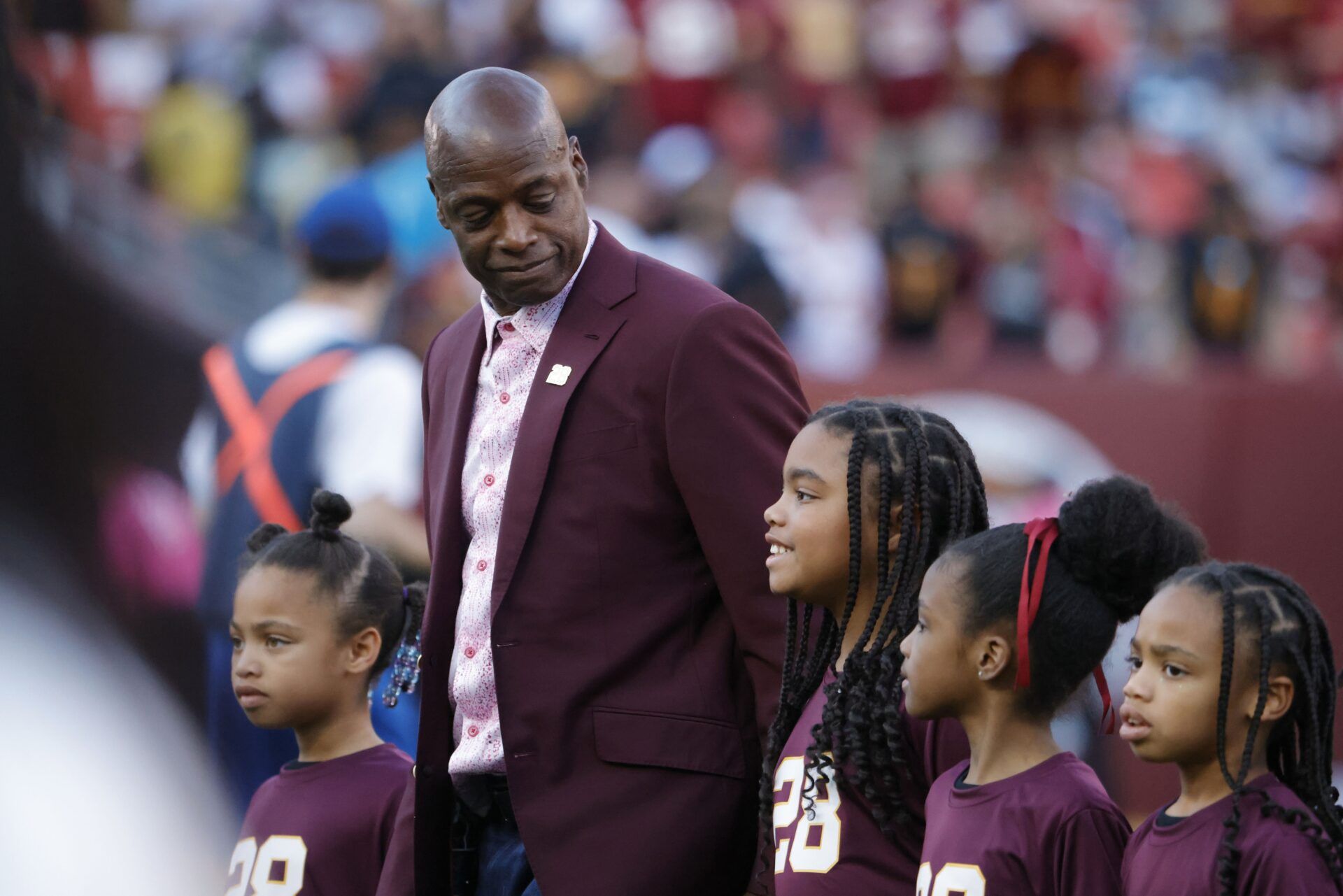 Former Washington Commanders Darrell Green (center) walks off the field with his family during a halftime celebration for his jersey retirement at Northwest Stadium against the Carolina Panthers.