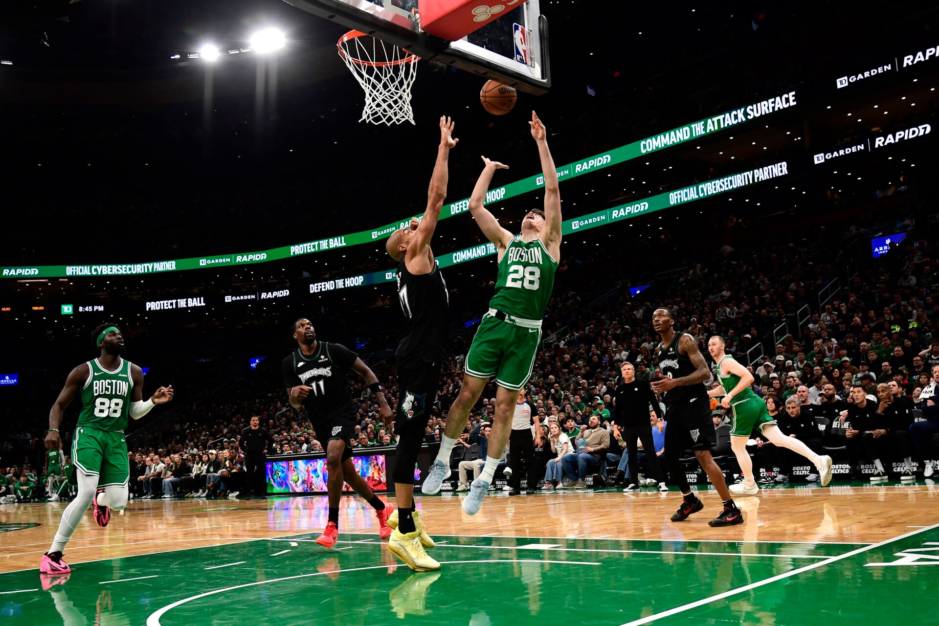 Minnesota Timberwolves center Rudy Gobert (27) and Boston Celtics guard Hugo Gonzalez (28) battle for the ball during the first half at TD Garden.