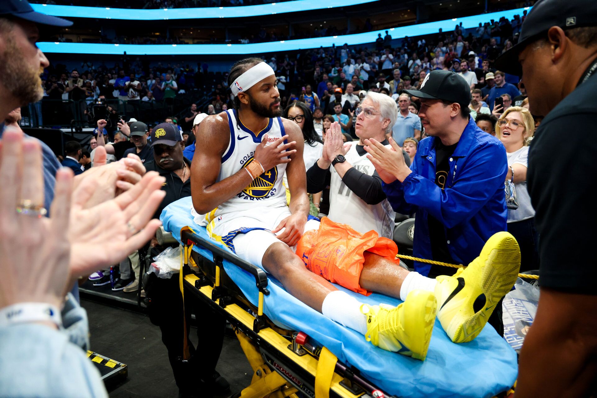Golden State Warriors guard Moses Moody (4) waves to fans while leaving the court on a stretcher during overtime against the Dallas Mavericks at American Airlines Center.