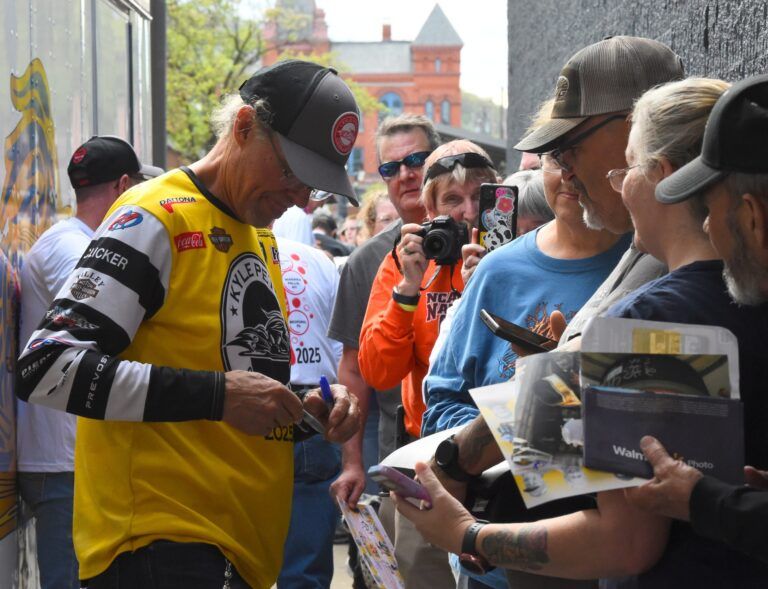 Retired NASCAR driver and longtime TV analyst Kyle Petty signs autographs during the Kyle Petty Charity Ride Across America's stop at the Radisson Hotel Corning on May 7, 2025 in Corning, New York.
