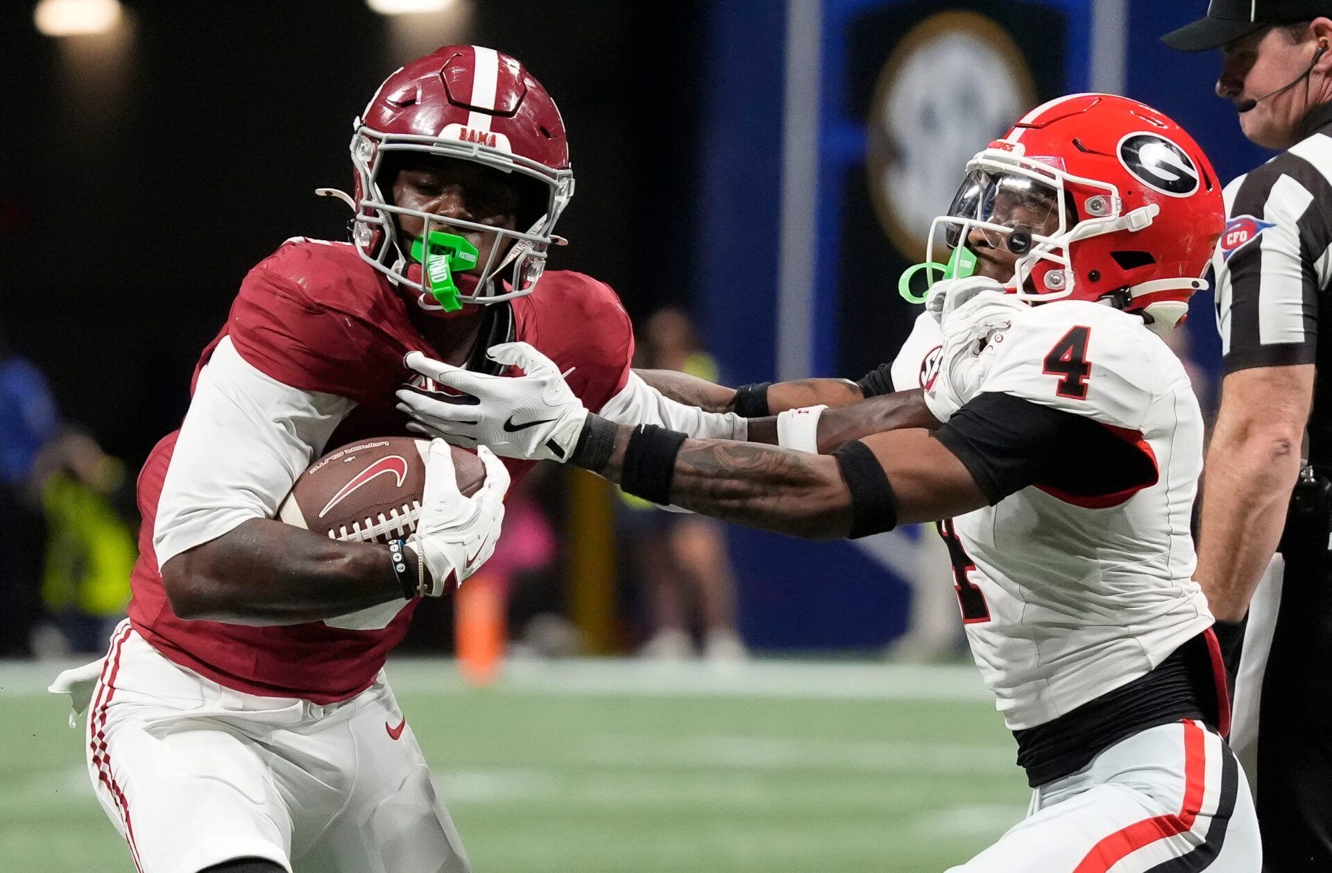 Alabama wide receiver Germie Bernard (5) uses a stiff arm to break a tackle by Georgia defensive back KJ Bolden (4) at Mercedes-Benz Stadium.