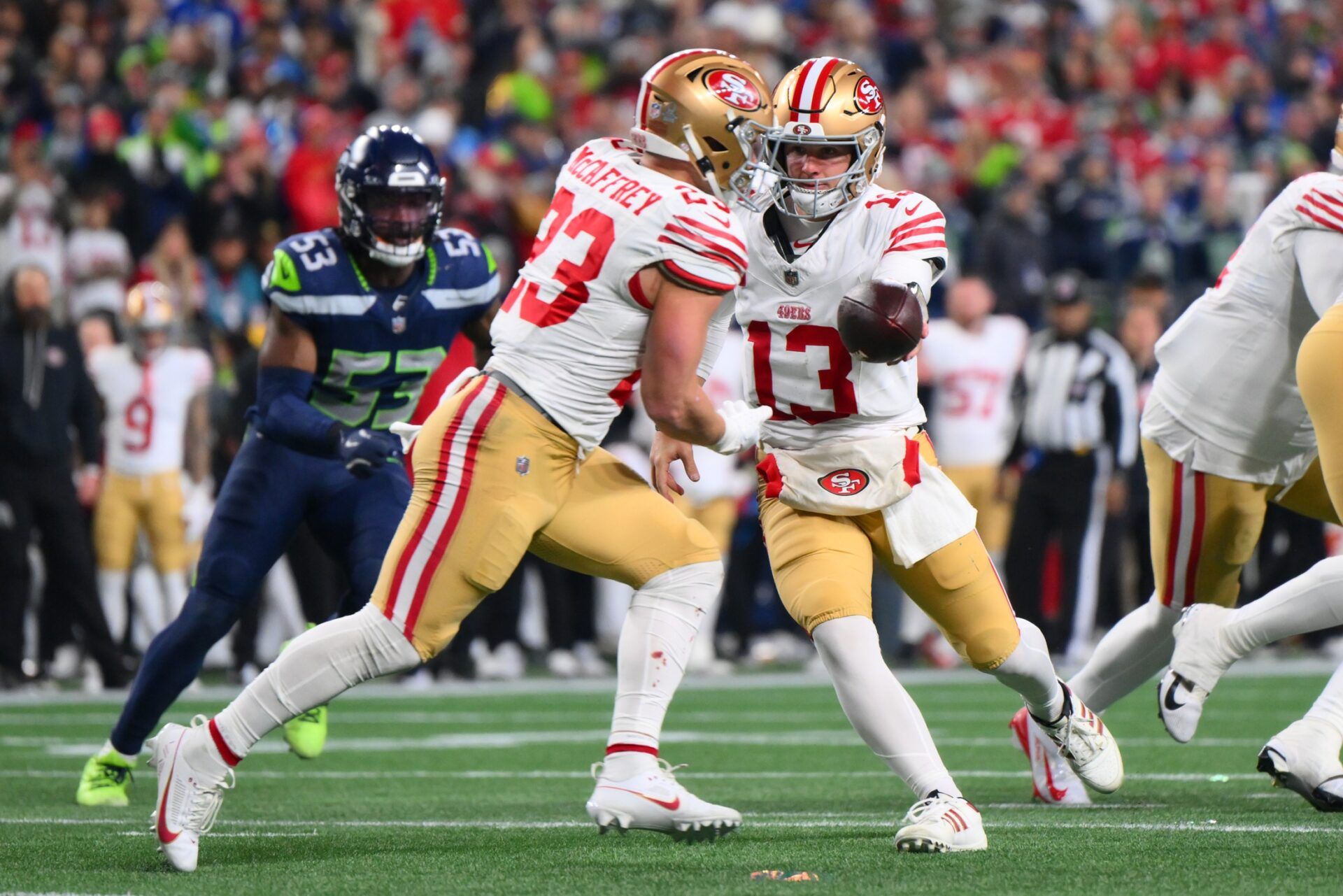 San Francisco 49ers quarterback Brock Purdy (13) hands off to running back Christian McCaffrey (23) against the Seattle Seahawks during the first half in an NFC Divisional Round game at Lumen Field.