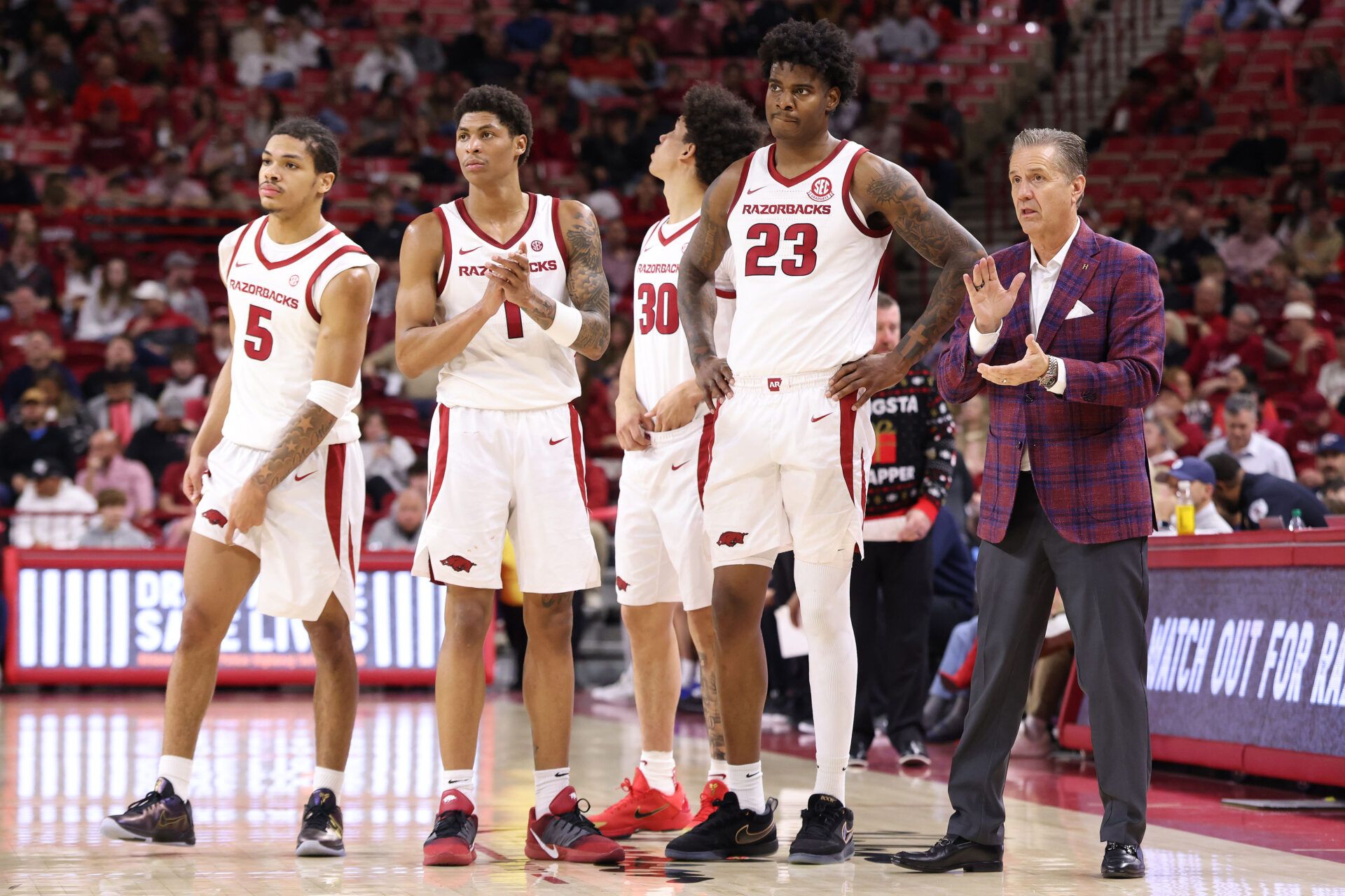 Arkansas Razorbacks head coach John Calipari talks to forward Nick Pringle (23), along with guards Meleek Thomas (1) and Darius Acuff Jr (5) during the second half against the Queens Royals at Bud Walton Arena. Arkansas won 108-80.