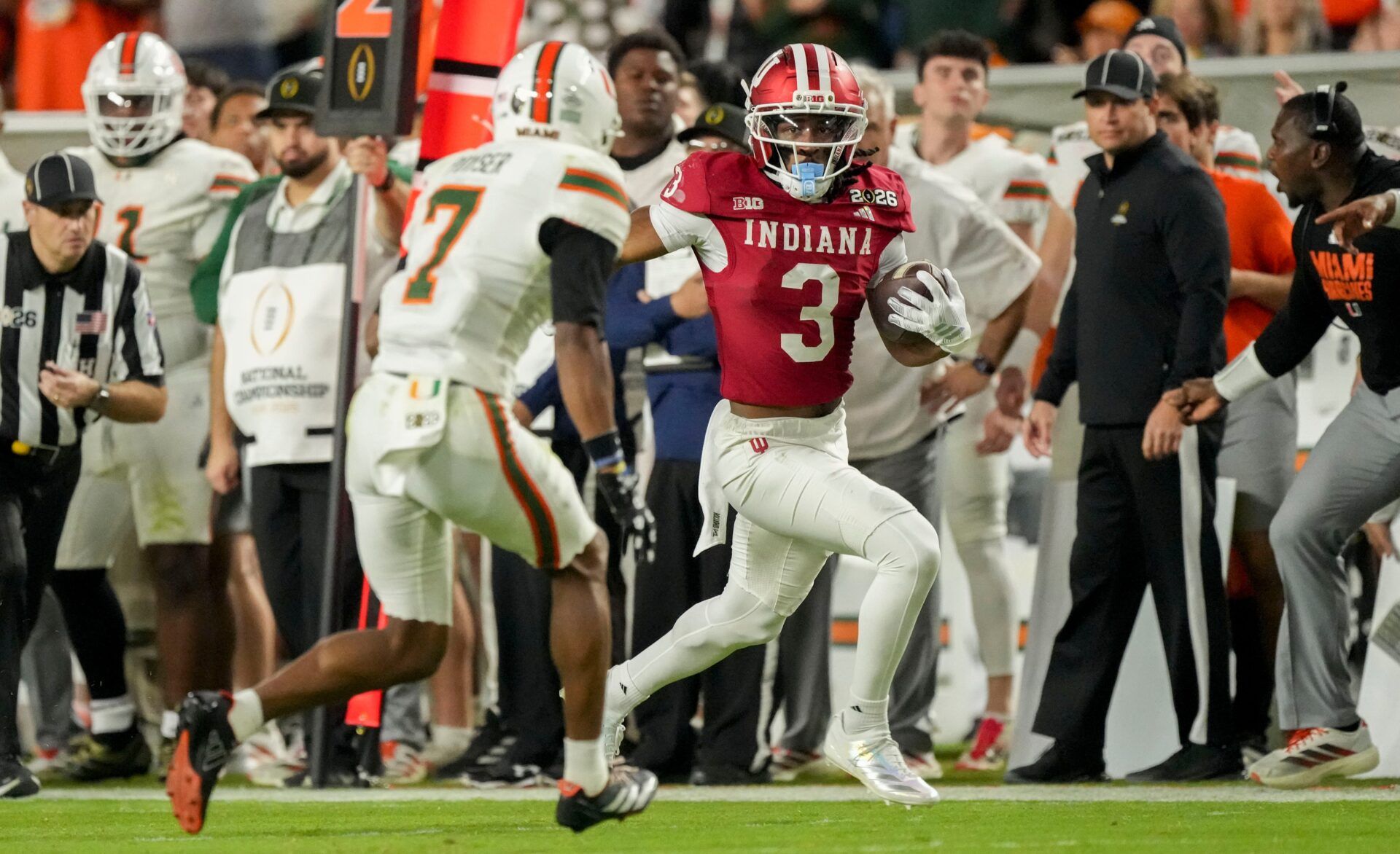 Indiana Hoosiers wide receiver Omar Cooper Jr. (3) runs down the sideline past Miami (FL) Hurricanes defenders Monday, Jan. 19, 2026, during the College Football Playoff National Championship college football game at Hard Rock Stadium in Miami Gardens.