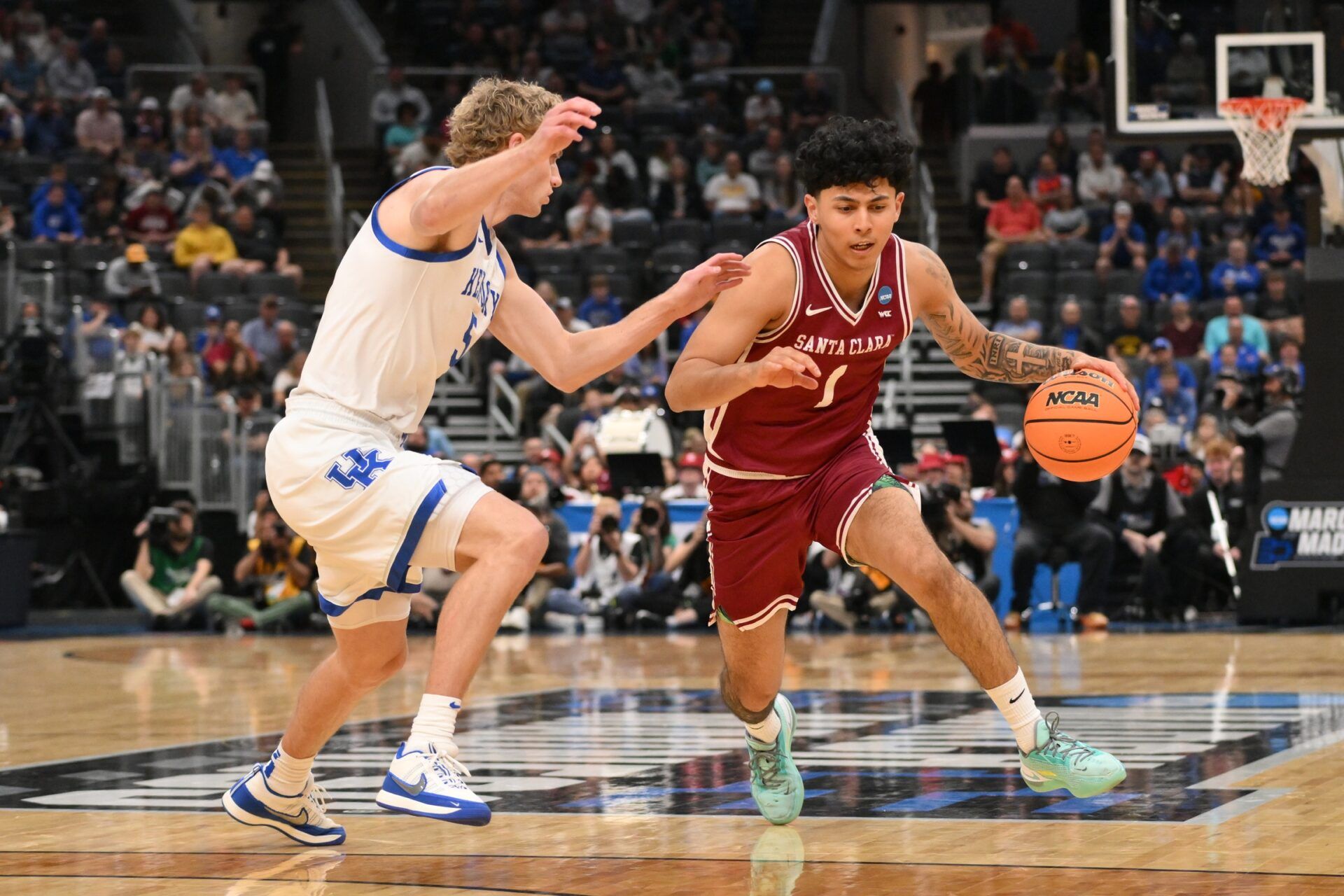 Santa Clara Broncos guard Christian Hammond (1) dribbles the ball against Kentucky Wildcats guard Collin Chandler (5) during the first half of a first round game of the men's 2026 NCAA Tournament at Enterprise Center.