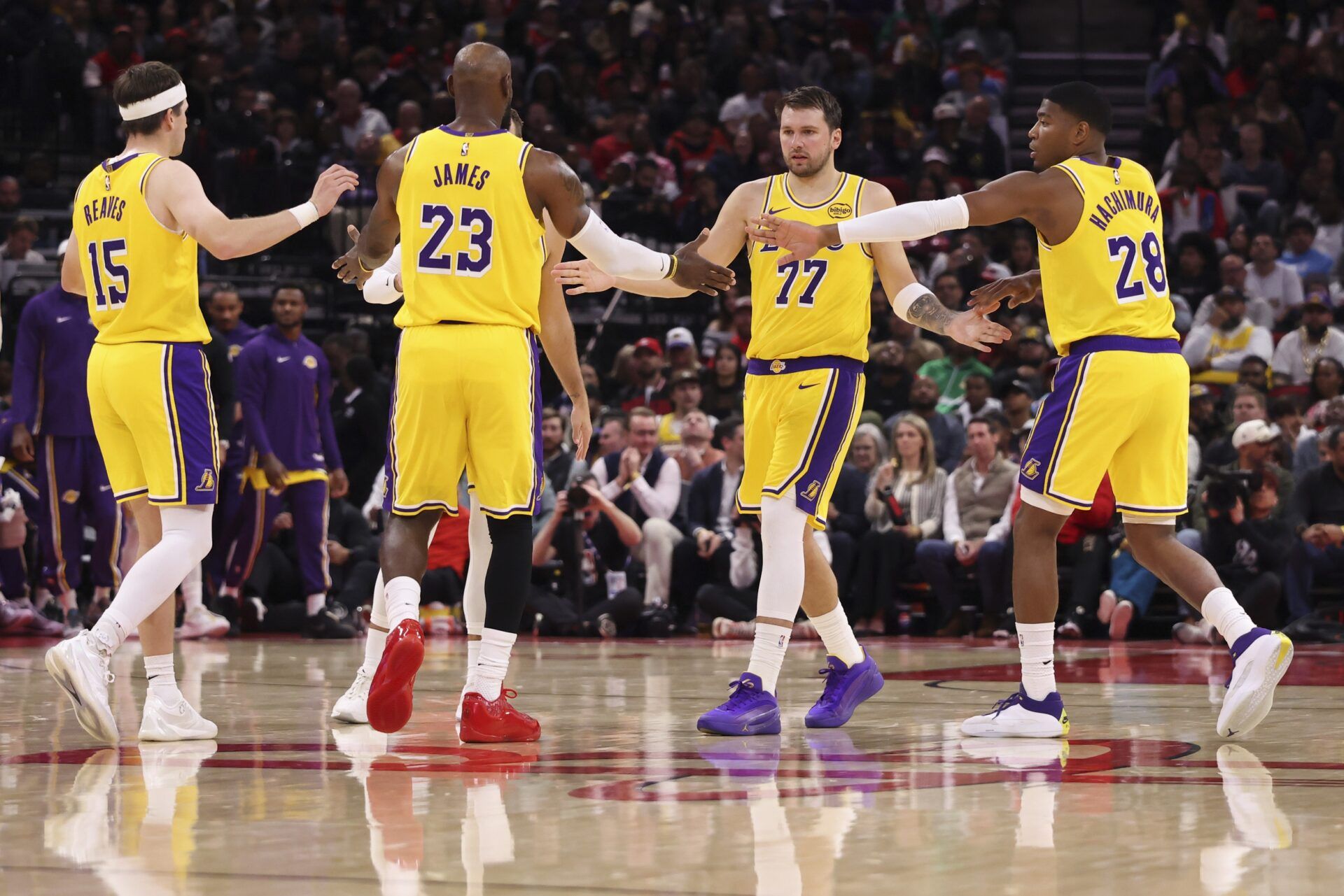 Los Angeles Lakers guard Luka Doncic (77) and forward LeBron James (23) celebrate with teammates after a play during the third quarter against the Houston Rockets at Toyota Center.