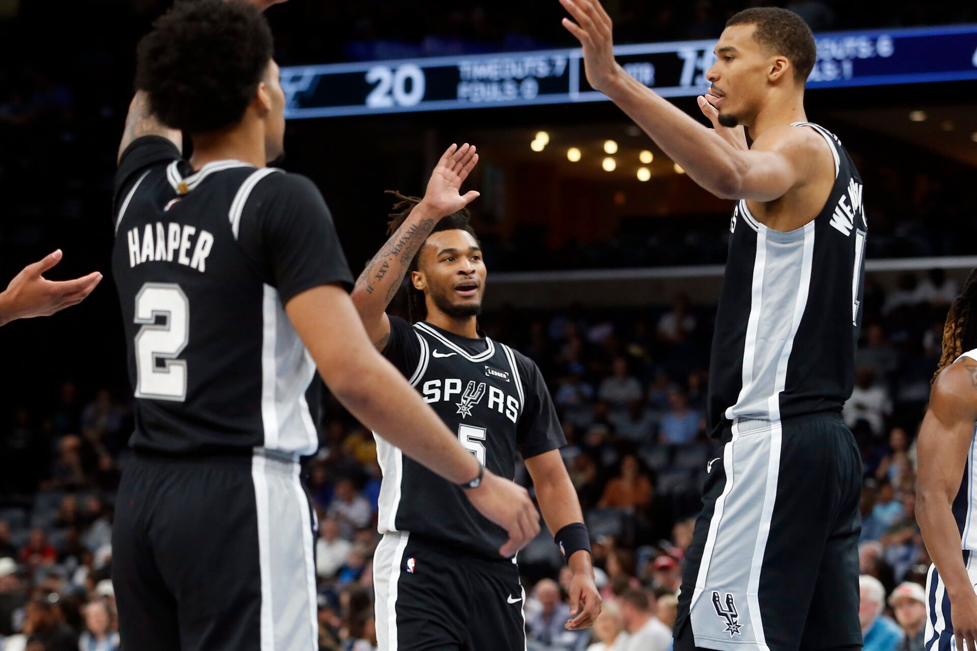 San Antonio Spurs guard Stephon Castle (5) reacts with guard Dylan Harper (2) and forward Victor Wembanyama (1) during the first quarter against the Memphis Grizzlies at FedExForum.