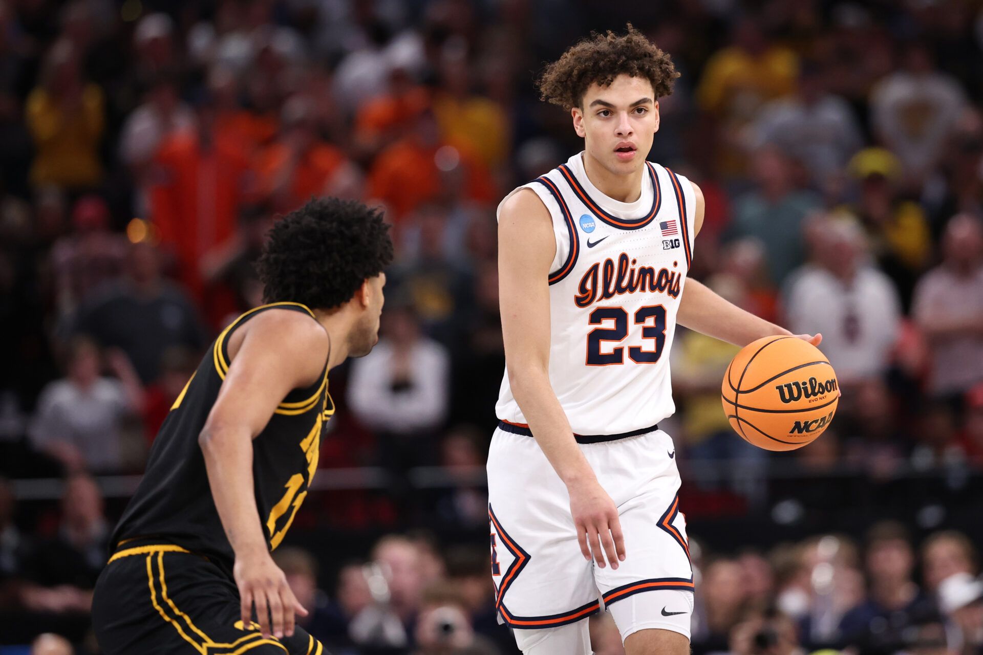 Illinois Fighting Illini guard Keaton Wagler (23) controls the ball against Iowa Hawkeyes guard Kael Combs (11) in the first half during an Elite Eight game of the South Regional of the men's 2026 NCAA Tournament at Toyota Center.