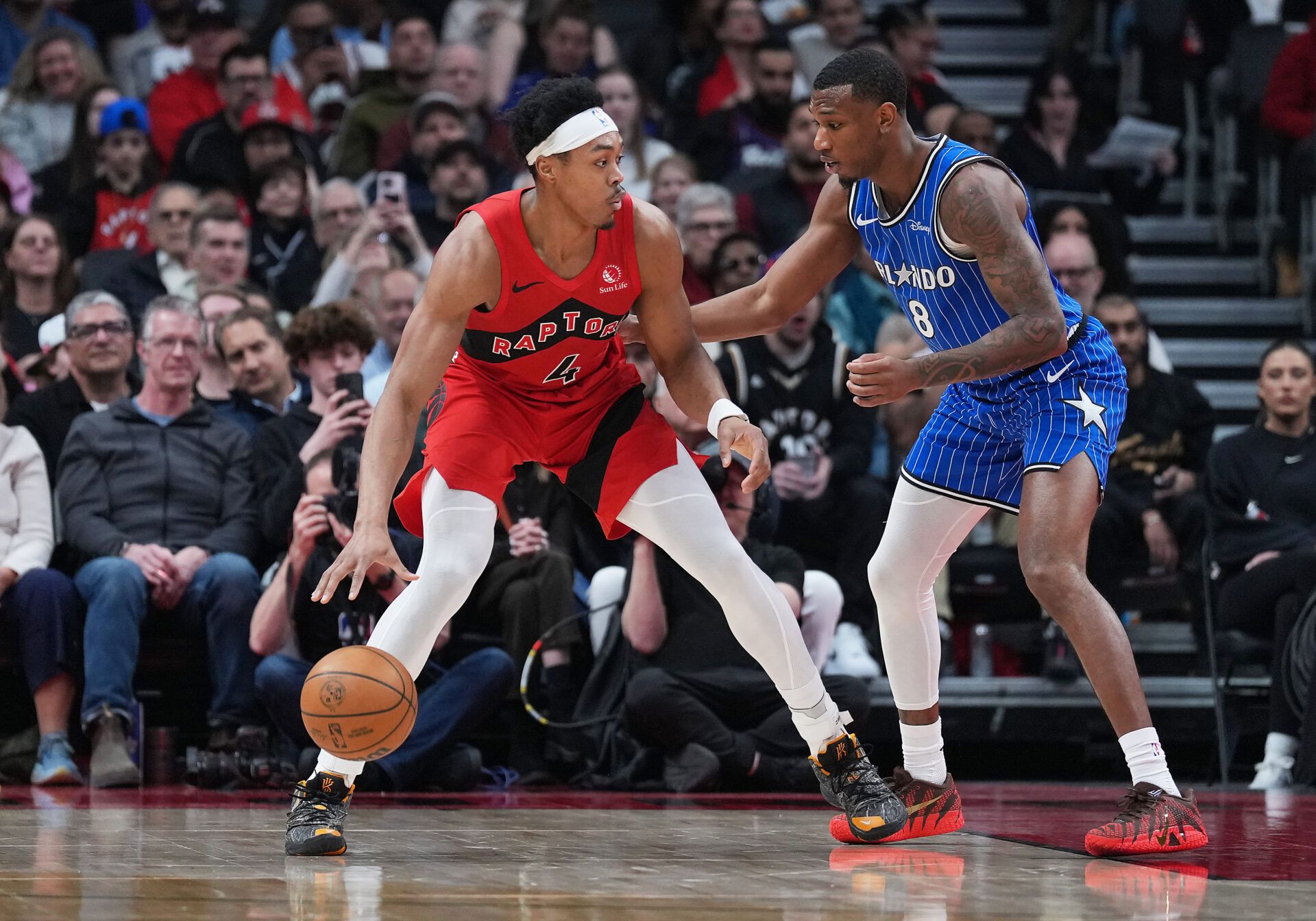 Toronto Raptors forward Scottie Barnes (4) controls the ball as Orlando Magic forward Jamal Cain (8) tries to defend during the first quarter at Scotiabank Arena.