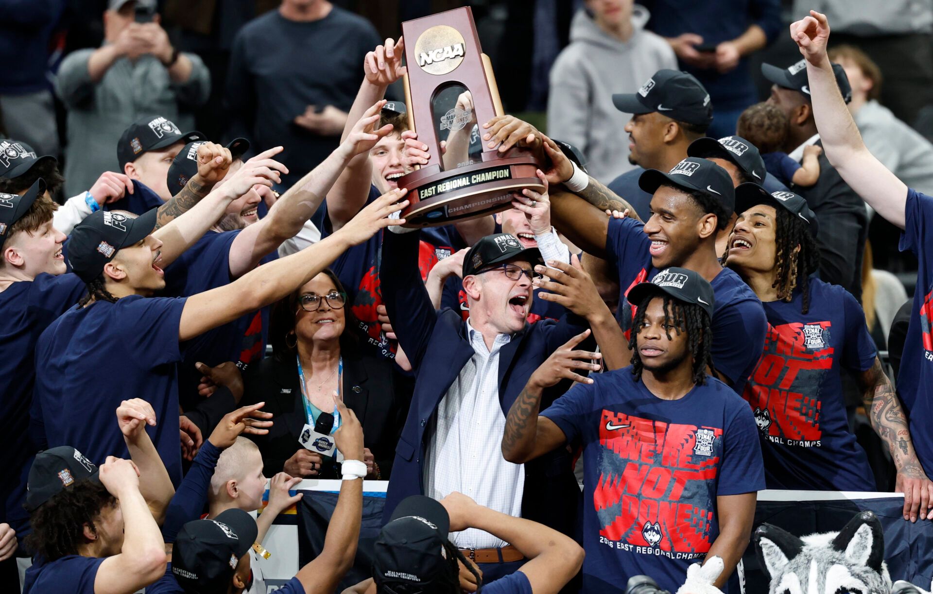 UConn Huskies head coach Dan Hurley hoists the east regional trophy after defeating the Duke Blue Devils in an Elite Eight game of the East Regional of the men's 2026 NCAA Tournament at Capital One Arena.
