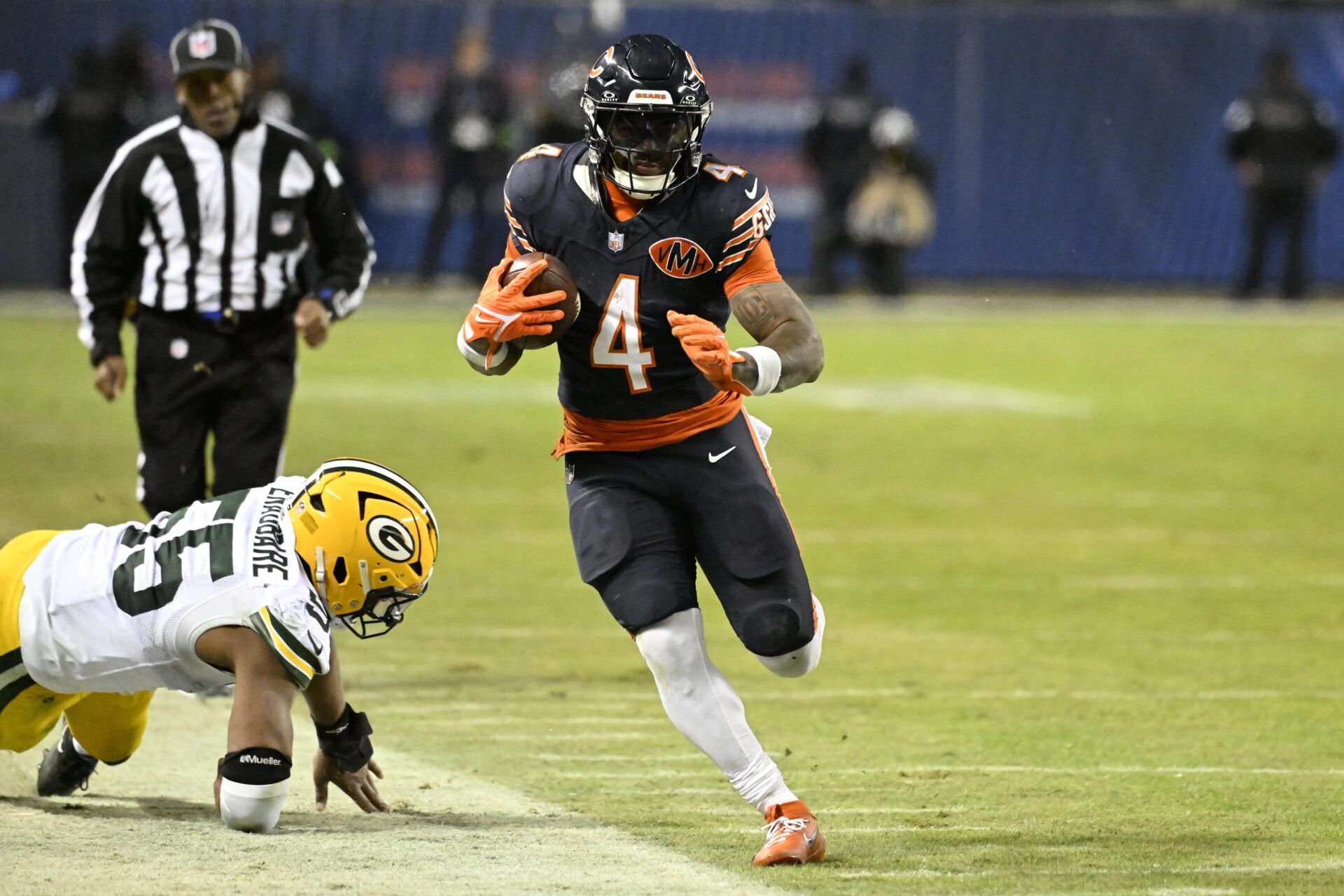 Chicago Bears running back D'Andre Swift (4) runs runs after the catch as Green Bay Packers defensive end Kingsley Enagbare (55) defends during the second half of an NFC Wild Card Round game at Soldier Field.