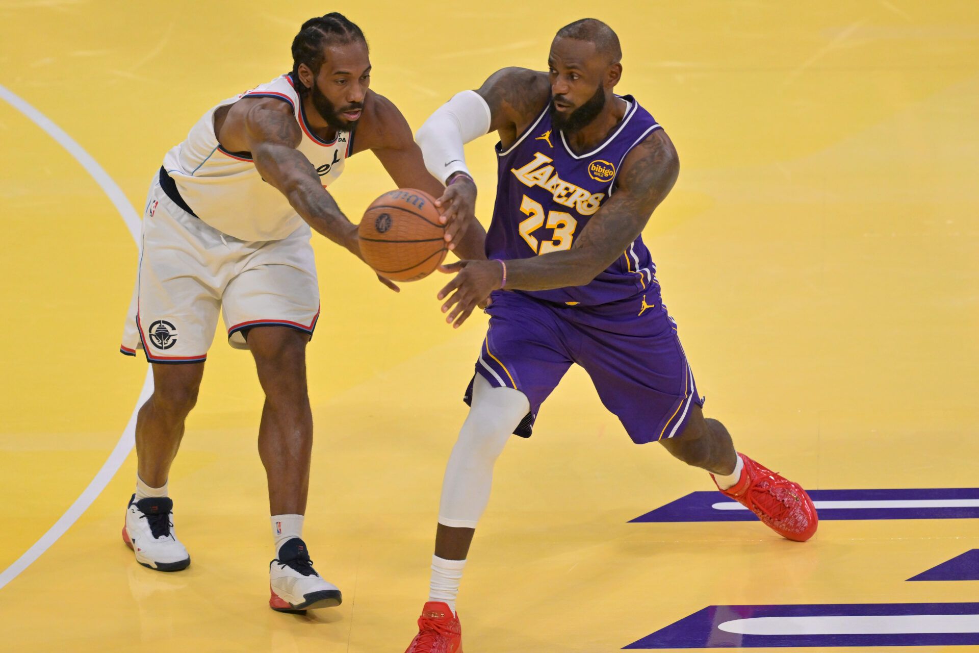 Los Angeles Clippers forward Kawhi Leonard (2) defends a pass by Los Angeles Lakers forward LeBron James (23) in the second half at Crypto.com Arena.