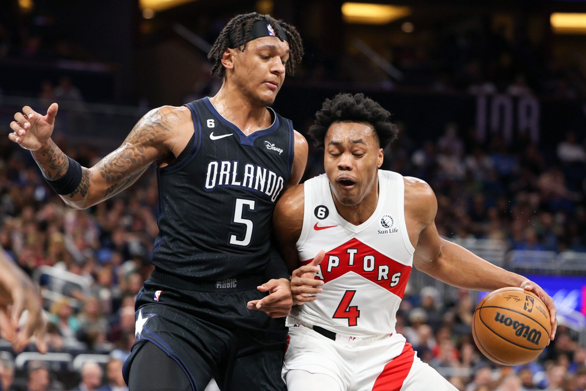 Orlando Magic forward Paolo Banchero (5) guards Toronto Raptors forward Scottie Barnes (4) in the first quarter at Amway Center.