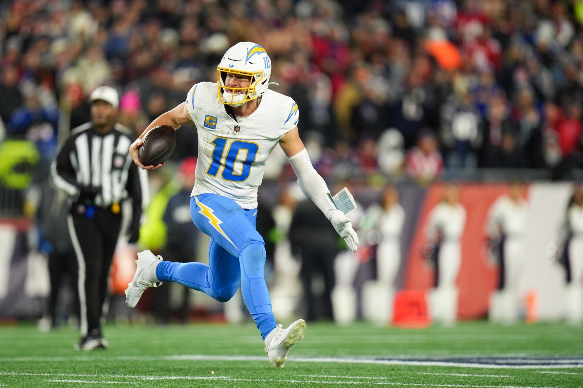Los Angeles Chargers quarterback Justin Herbert (10) scrambles during the fourth quarter against the New England Patriots in an AFC Wild Card Round game at Gillette Stadium.