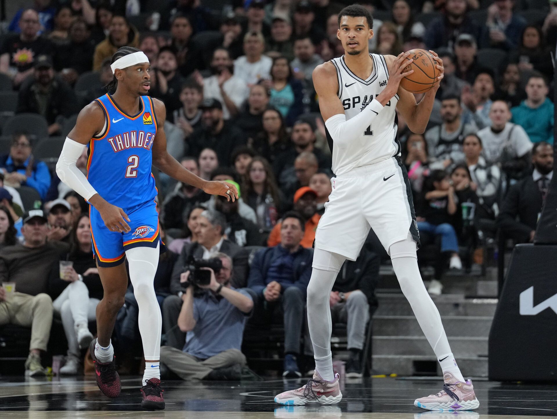San Antonio Spurs center Victor Wembanyama (1) looks down the court beside Oklahoma City Thunder guard Shai Gilgeous-Alexander (2) in the first half at Frost Bank Center.