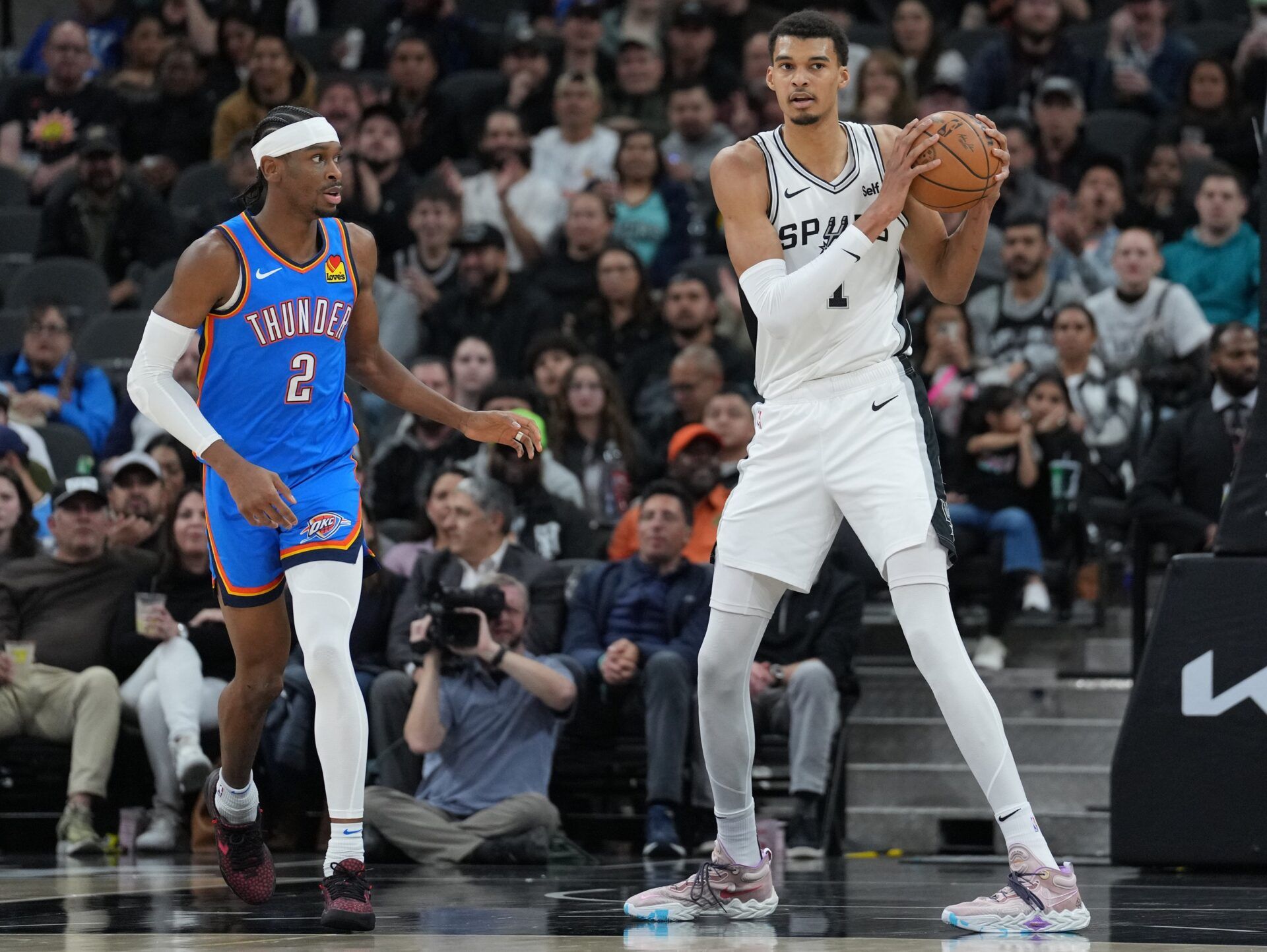 San Antonio Spurs center Victor Wembanyama (1) looks down the court beside Oklahoma City Thunder guard Shai Gilgeous-Alexander (2) in the first half at Frost Bank Center.