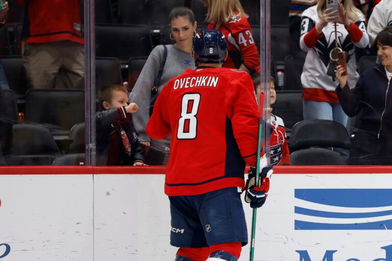 Washington Capitals left wing Alex Ovechkin (8) fist bumps his family through the glass after the game against the Philadelphia Flyers at Capital One Arena.