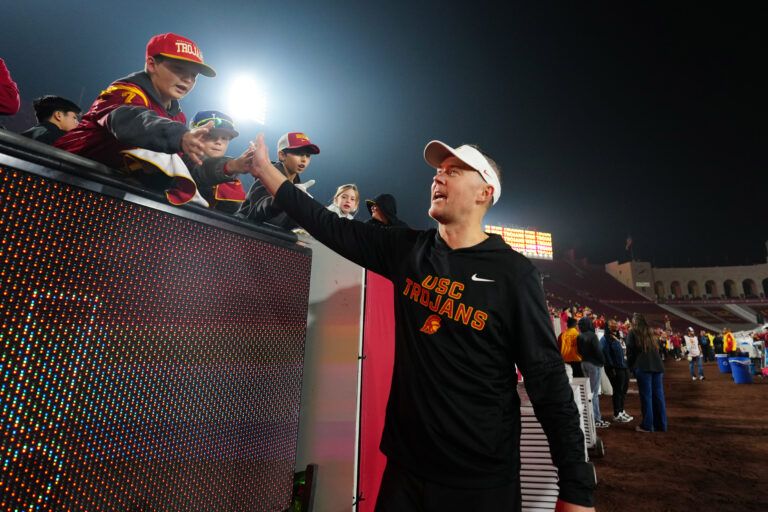 Southern California Trojans head coach Lincoln Riley celebrates with fans after the game against the UCLA Bruins at United Airlines Field at Los Angeles Memorial Coliseum.