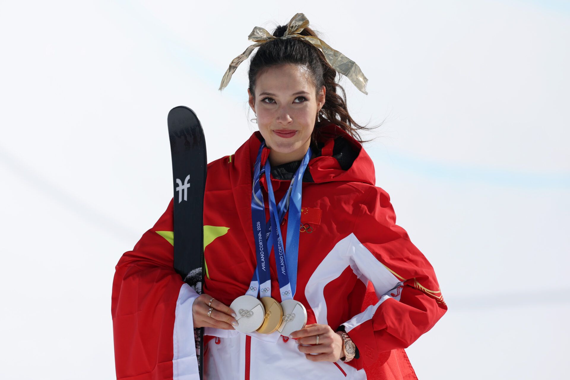 Gold medalist Ailing Eileen Gu of the People's Republic of China poses for a photo with her three medals after the medal ceremony for the women's skiing halfpipe during the Milano Cortina 2026 Olympic Winter Games at Livigno Snow Park.