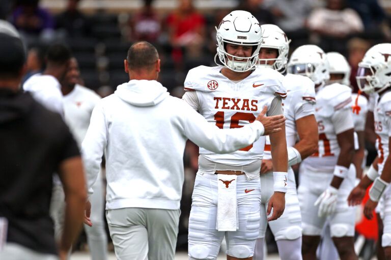 Texas Longhorns quarterback Arch Manning (16) runs the ball with head coach Steve Sarkisian during warm ups prior to the game against the Mississippi State Bulldogs at Davis Wade Stadium at Scott Field.