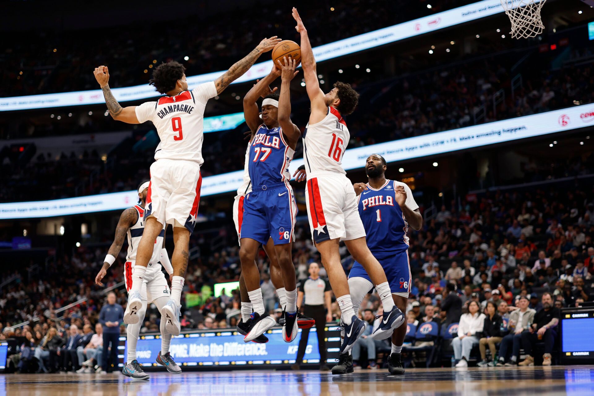 Philadelphia 76ers guard Vj Edgecombe (77) leaps to pass the ball as Washington Wizards forward Justin Champagnie (9) and Wizards forward Anthony Gill (16) defend in the first half at Capital One Arena.