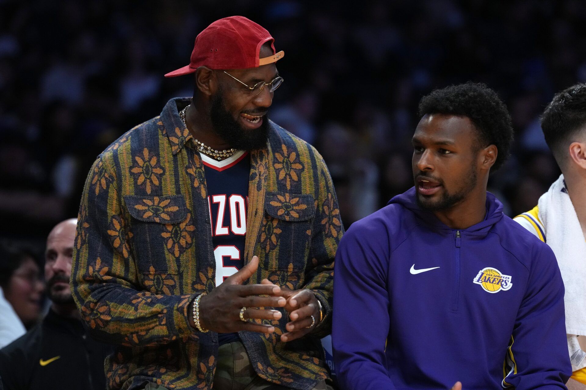 Los Angeles Lakers forward LeBron James (left) and son Bronny James  watch from the bench in the second half against the Minnesota Timberwolves at Crypto.com Arena.