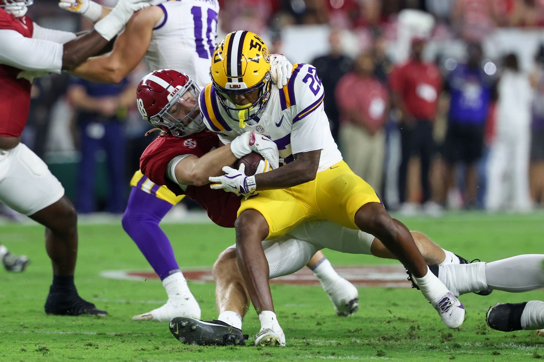Alabama Crimson Tide defensive back Bray Hubbard (18) tackles Louisiana State Tigers running back Harlem Berry (22) during the first quarter of the game at Saban Field at Bryant-Denny Stadium.