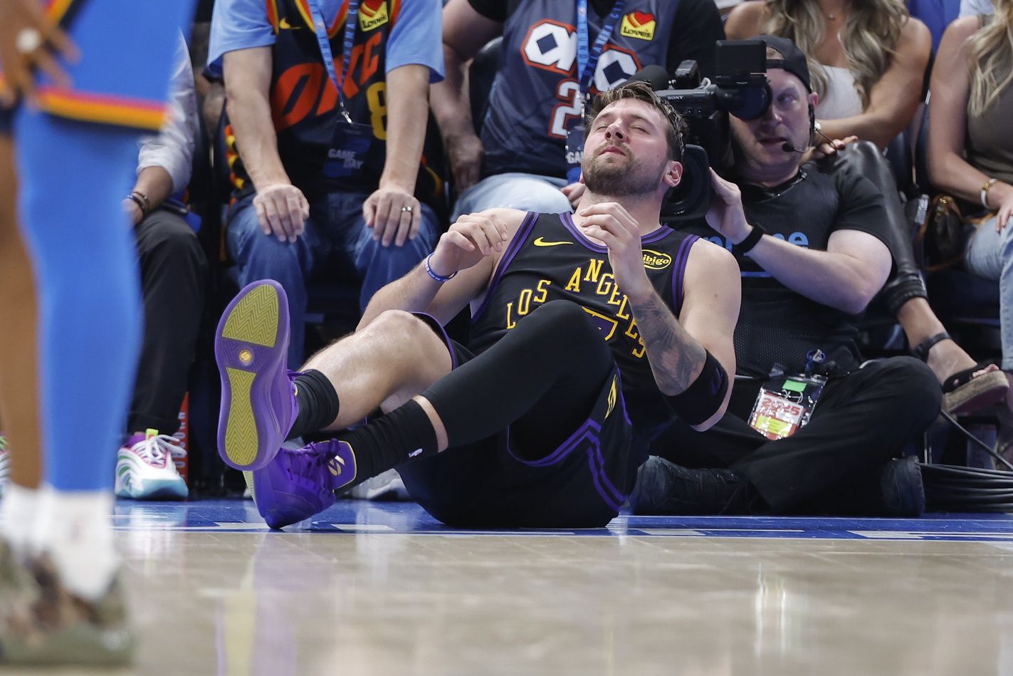 Los Angeles Lakers guard Luka Doncic (77) falls to the court during a play against the Oklahoma City Thunder during the third quarter at Paycom Center.