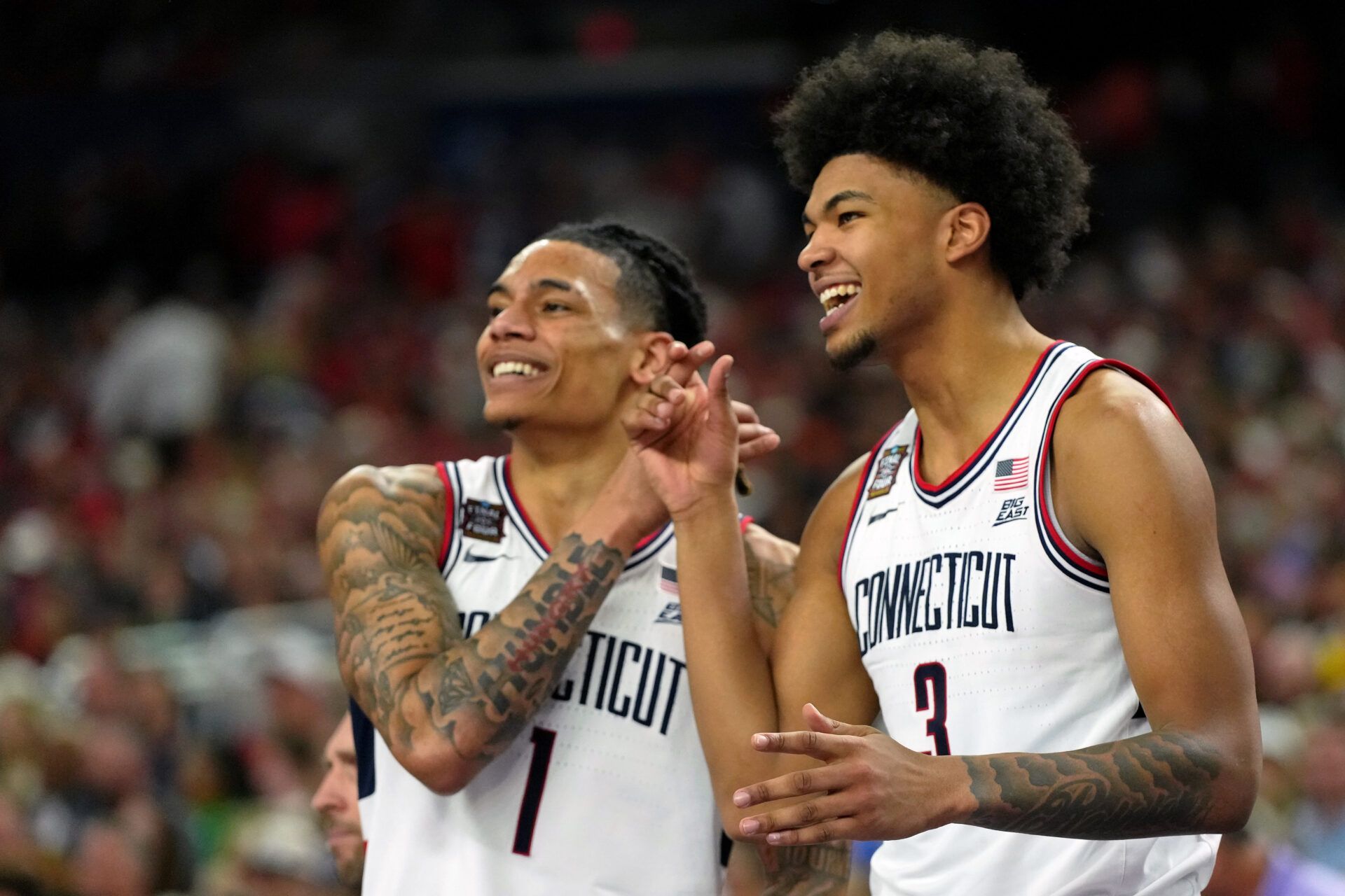 UConn Huskies guard Solo Ball (1) reacts with forward Jaylin Stewart (3) after a play against the Illinois Fighting Illini during the second half of a semifinal of the Final Four of the men's 2026 NCAA Tournament at Lucas Oil Stadium.