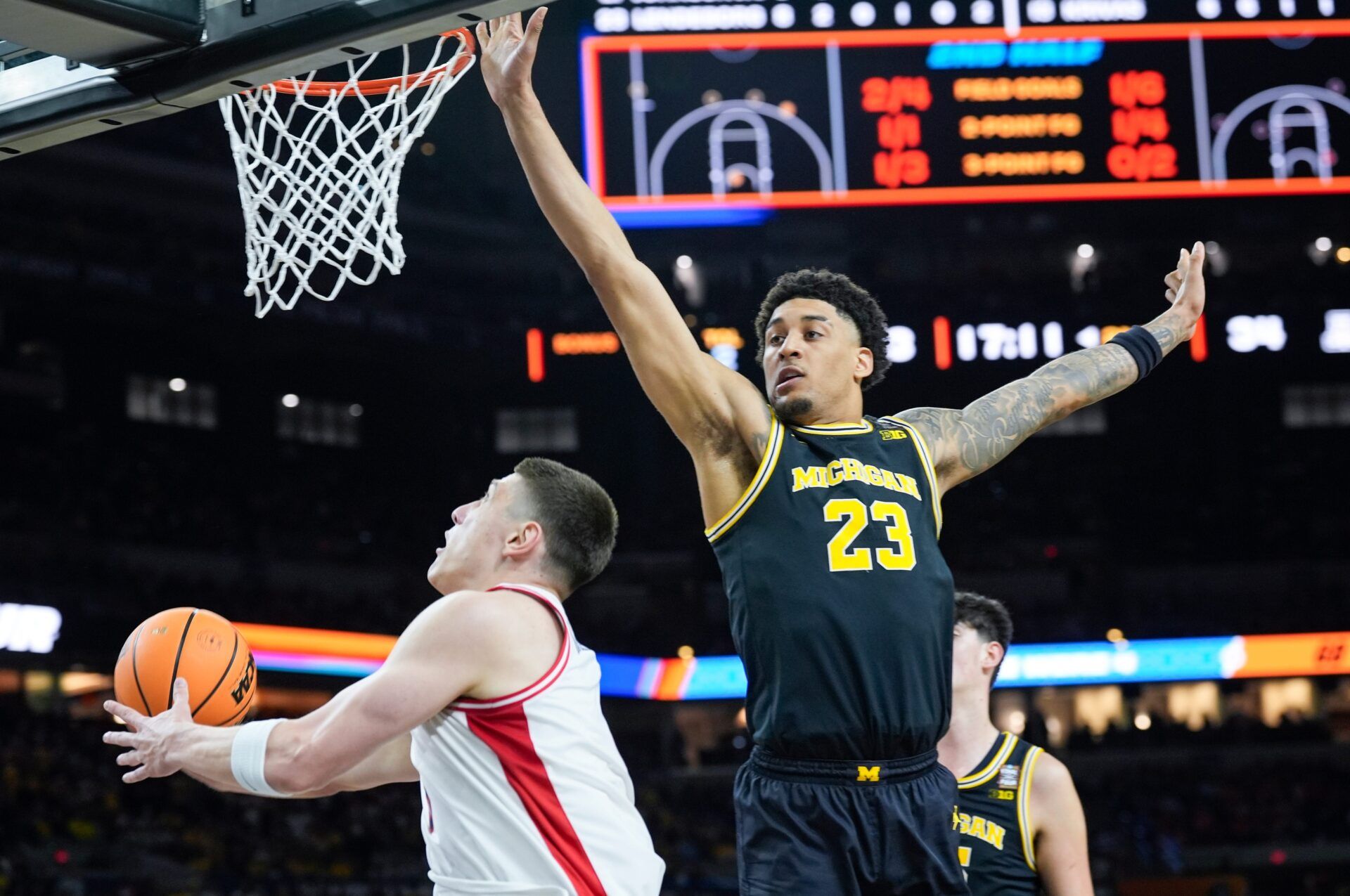 Arizona forward Ivan Kharchenkov (8) looks for a shot around Michigan forward Yaxel Lendeborg (23) in the second half of their Final Four game at Lucas Oil Stadium in Indianapolis on Saturday, April 4, 2026.