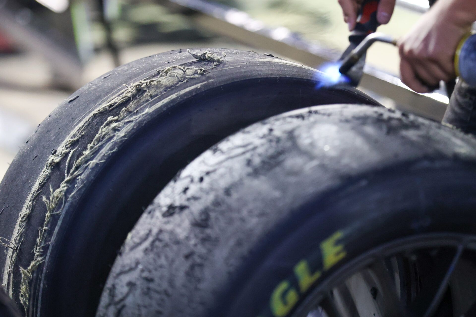 A NASCAR crewman scrapes tires after a pit stop at Bristol Motor Speedway.