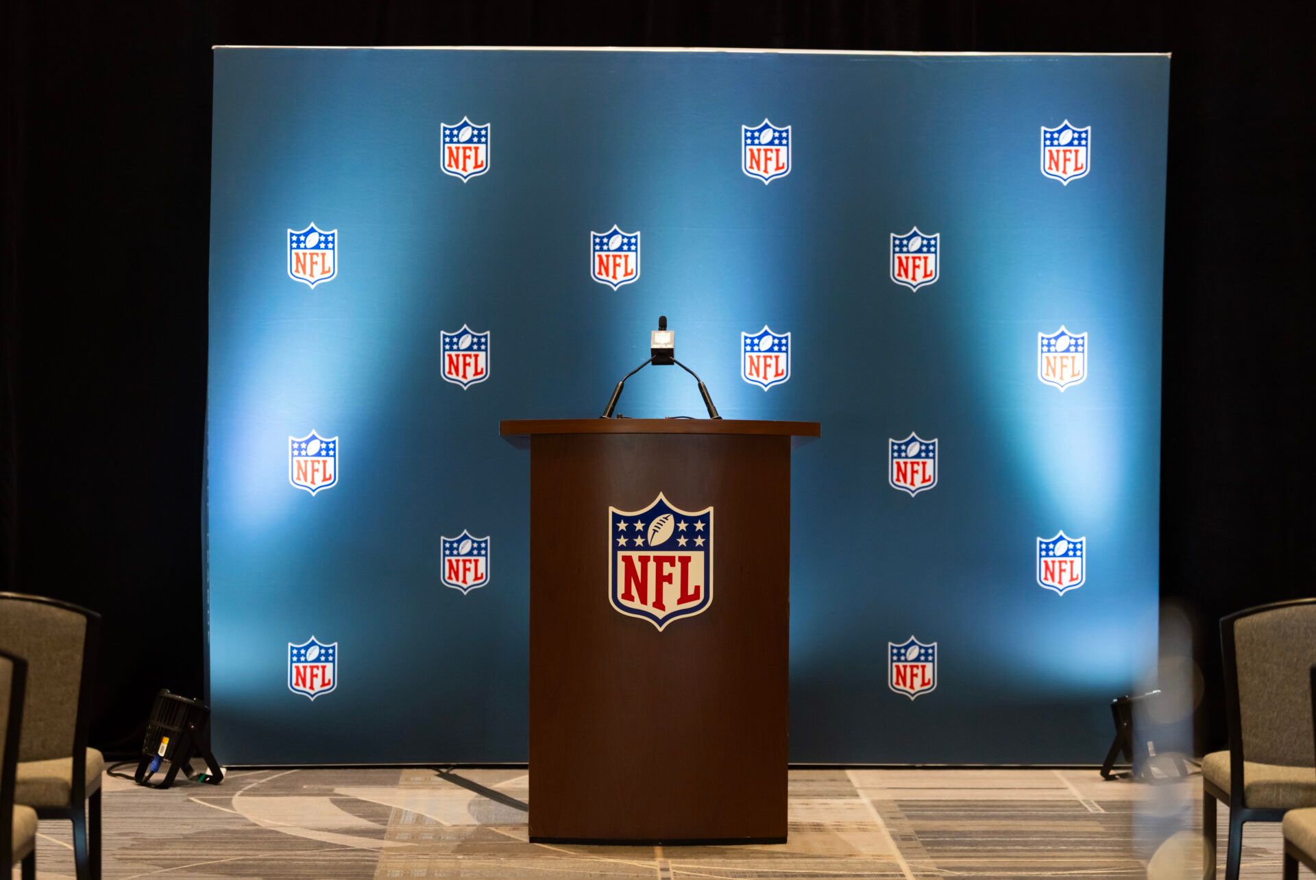 Detailed view of the NFL shield logo on a lectern in a press conference room during the 2026 NFL Annual League Meeting at the Arizona Biltmore.