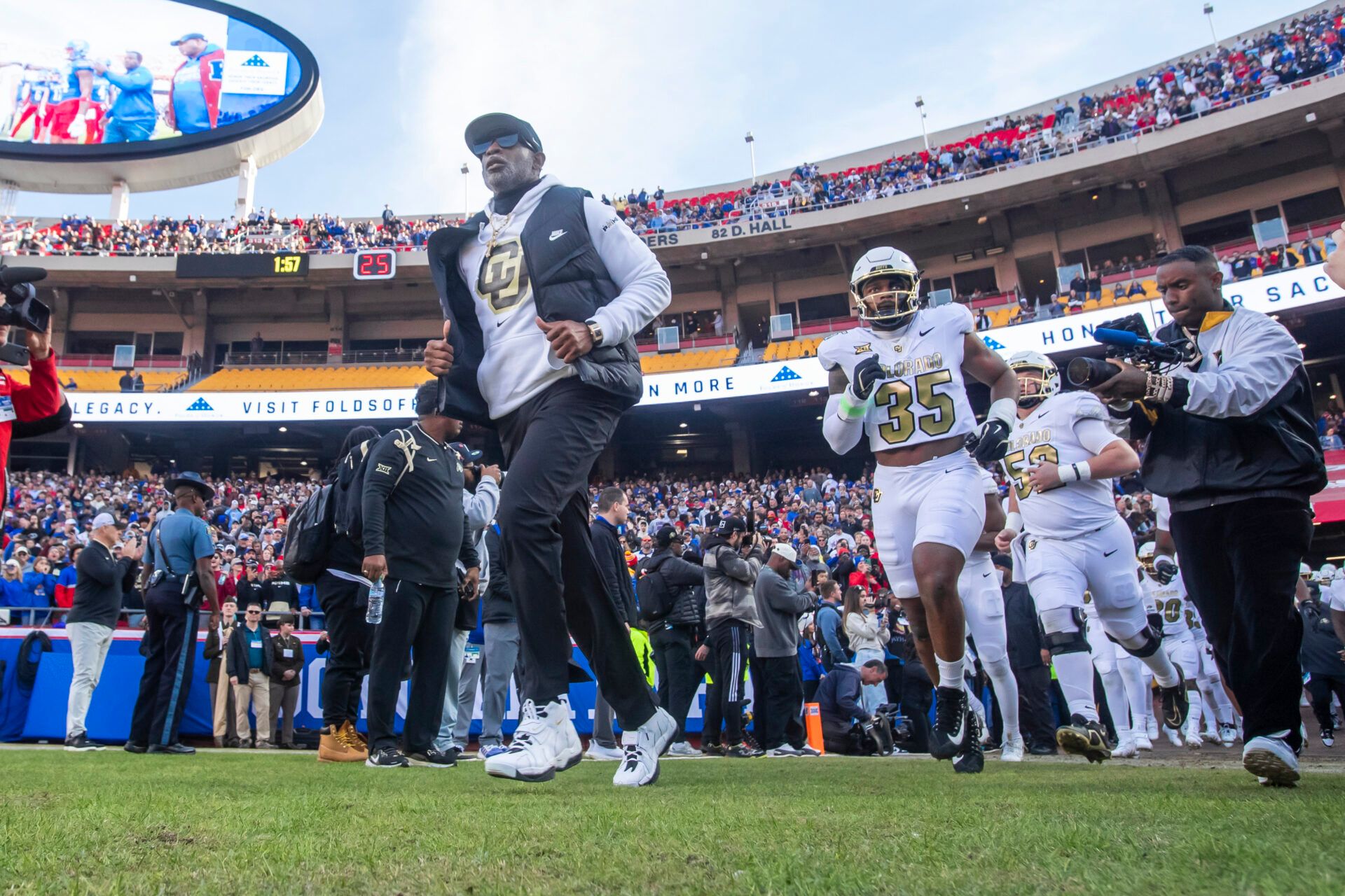 Colorado head coach Deion Sanders leads his team on to the field against  the Kansas Jayhawks at GEHA Field at Arrowhead Stadium.