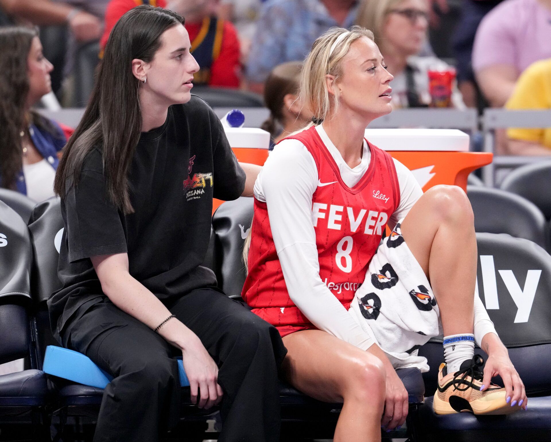 Indiana Fever guard Caitlin Clark (22) and guard Sophie Cunningham (8) watch from the bench during the first half of a game against the Washington Mystics on Friday, Aug. 15, 2025, at Gainbridge Fieldhouse in Indianapolis.
