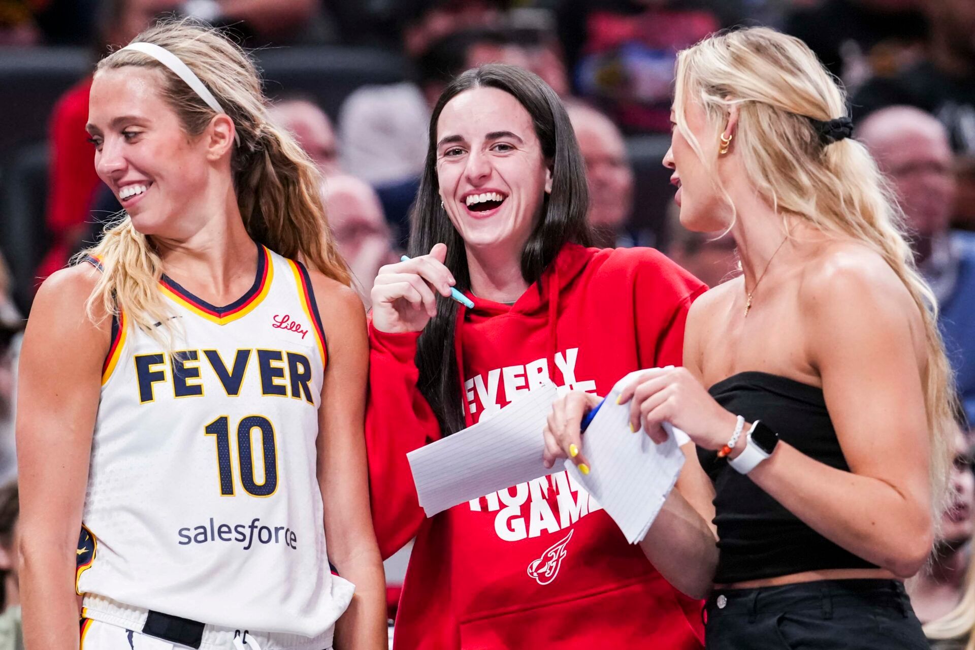 Indiana Fever guard Lexie Hull (10), guard Caitlin Clark (22), and guard Sophie Cunningham (8) laugh near the team bench during a game between the Indiana Fever and the Washington Mystics at Gainbridge Fieldhouse in Indianapolis.