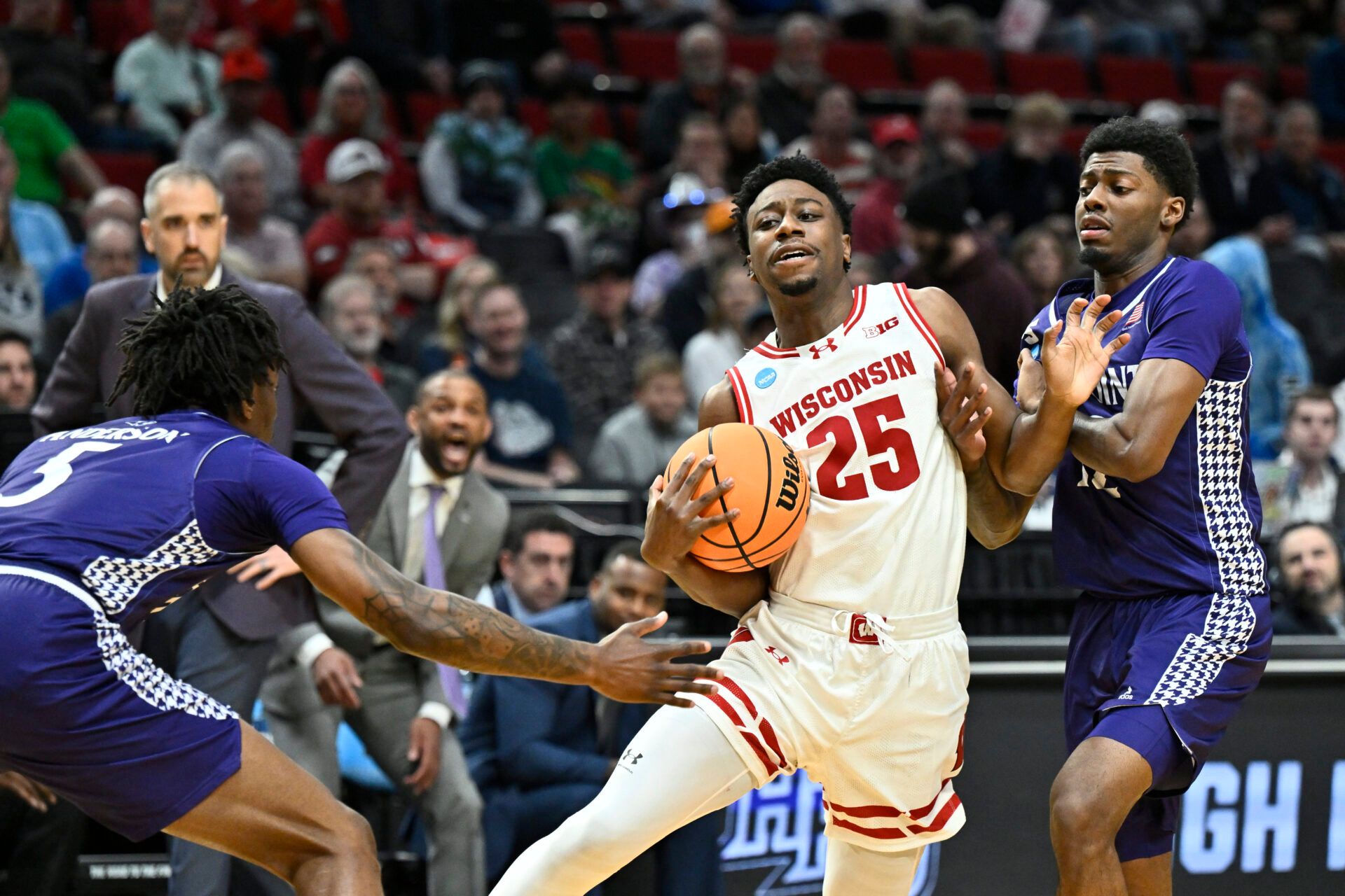 Wisconsin Badgers guard John Blackwell (25) controls the ball against High Point Panthers forward Terry Anderson (5) during the first half of a first round game of the men's 2026 NCAA Tournament at Moda Center.