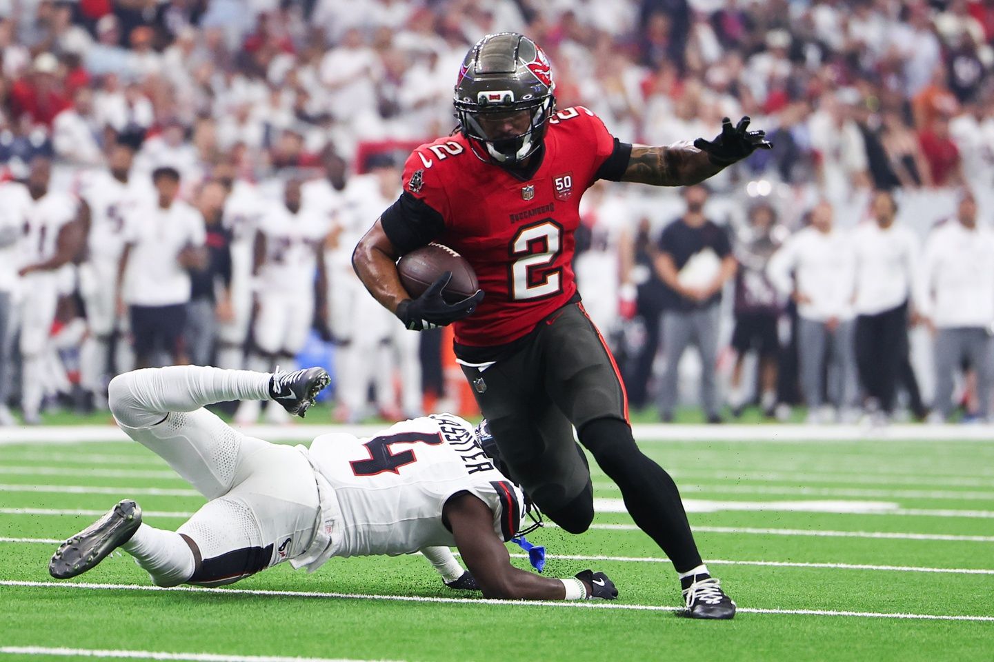 Tampa Bay Buccaneers wide receiver Emeka Egbuka (2) runs for a touchdown as Houston Texans cornerback Kamari Lassiter (4) defends during the second quarter at NRG Stadium.