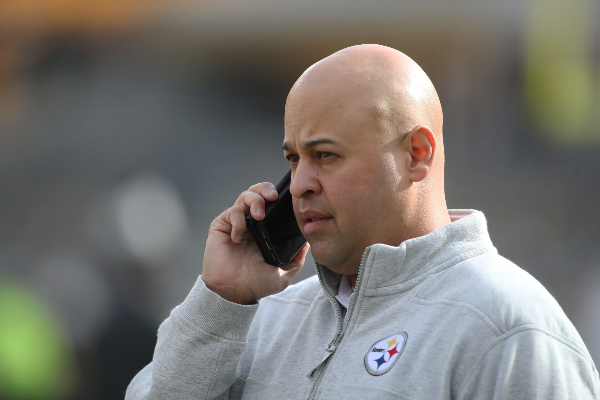 Pittsburgh Steelers general manager Omar Khan talks on the phone before the game against the Baltimore Ravens at Acrisure Stadium.