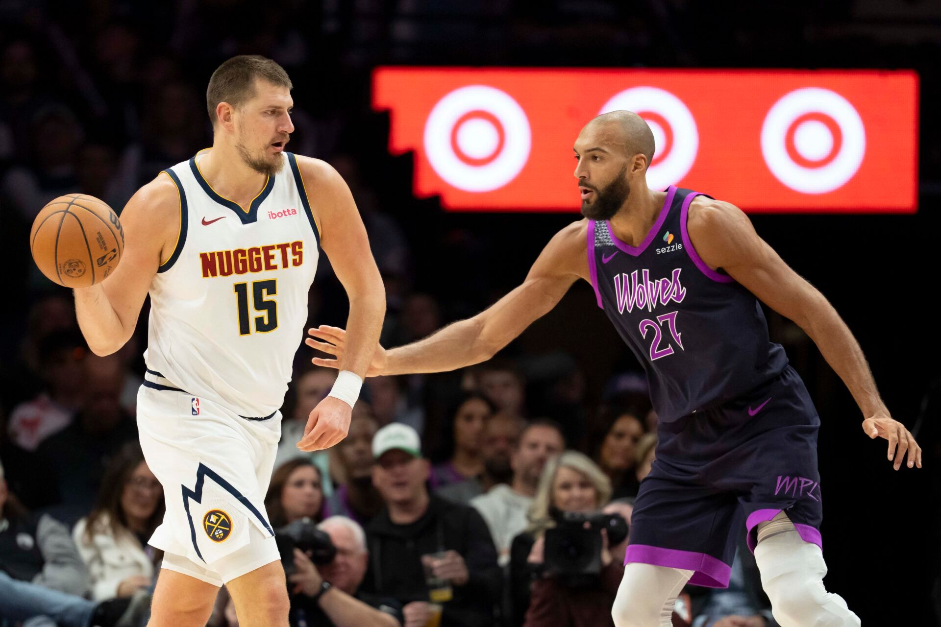 Denver Nuggets center Nikola Jokic (15) passes the ball as Minnesota Timberwolves center Rudy Gobert (27) plays defense in the first half at Target Center.