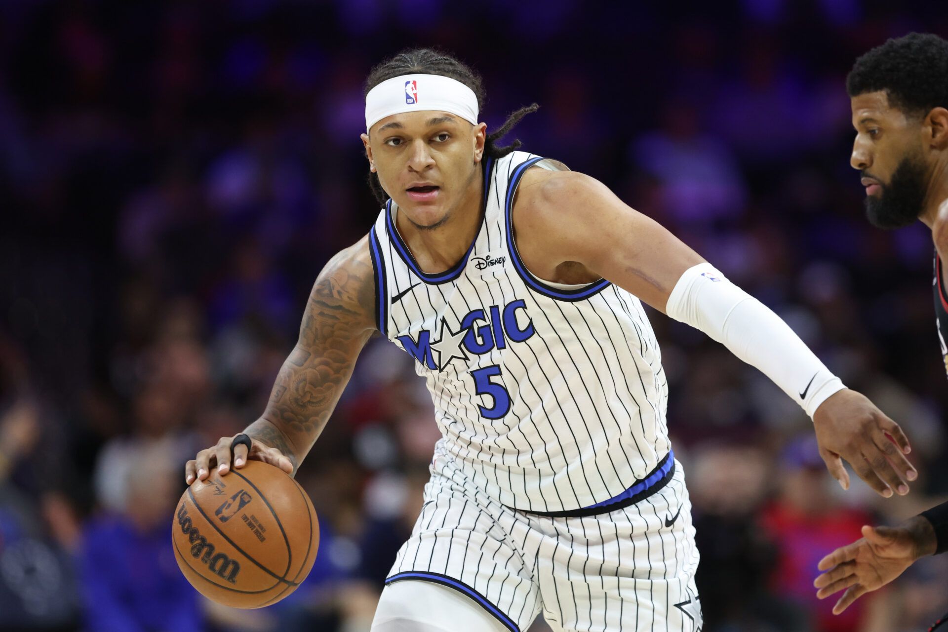 Orlando Magic forward Paolo Banchero (5) controls the ball against the Philadelphia 76ers during the first quarter during the play-in rounds of the 2026 NBA Playoffs at Xfinity Mobile Arena.