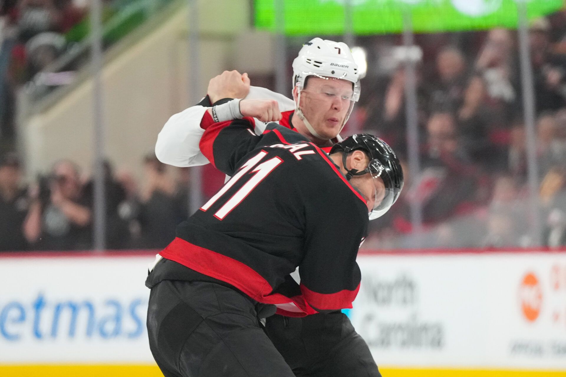 Ottawa Senators left wing Brady Tkachuk (7) and Carolina Hurricanes center Jordan Staal (11) fight during the first period in game one of the first round of the 2026 Stanley Cup Playoffs at Lenovo Center.