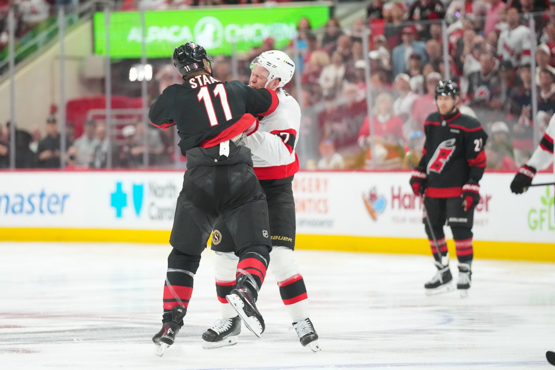 Ottawa Senators left wing Brady Tkachuk (7) and Carolina Hurricanes center Jordan Staal (11) fight during the first period in game one of the first round of the 2026 Stanley Cup Playoffs at Lenovo Center.