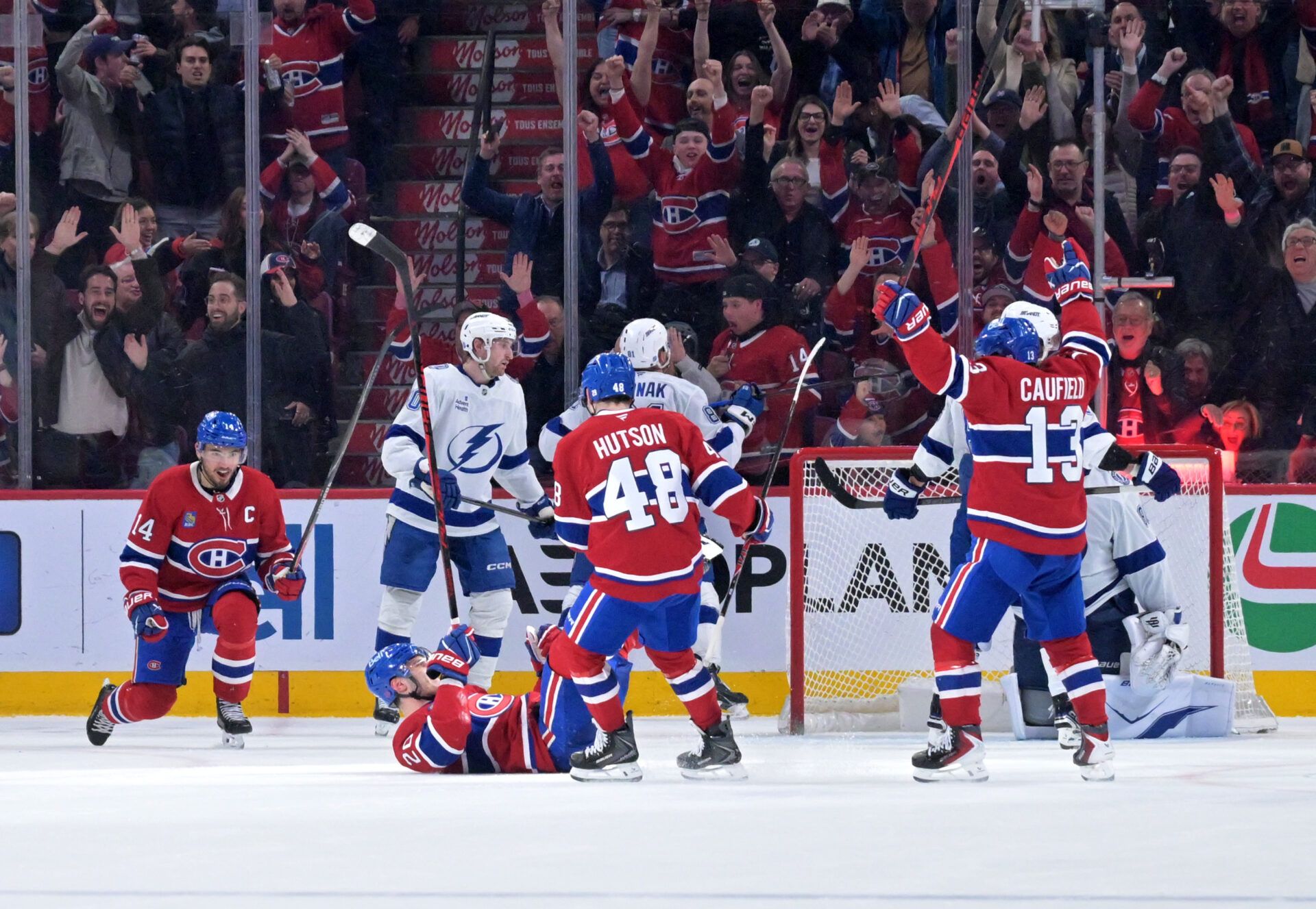 Montreal Canadiens forward Juraj Slafkovsky (20) celebrates with teammates including forward Cole Caufield (13) and forward Nick Suzuki (14) after scoring a goal against the Tampa Bay Lightning during the third period at the Bell Centre.